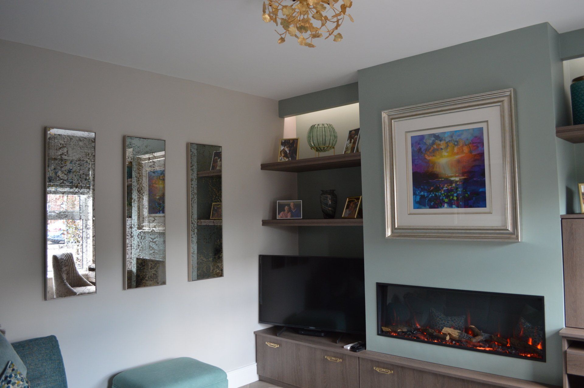 A living room with a fireplace , television , mirrors and a painting on the wall.