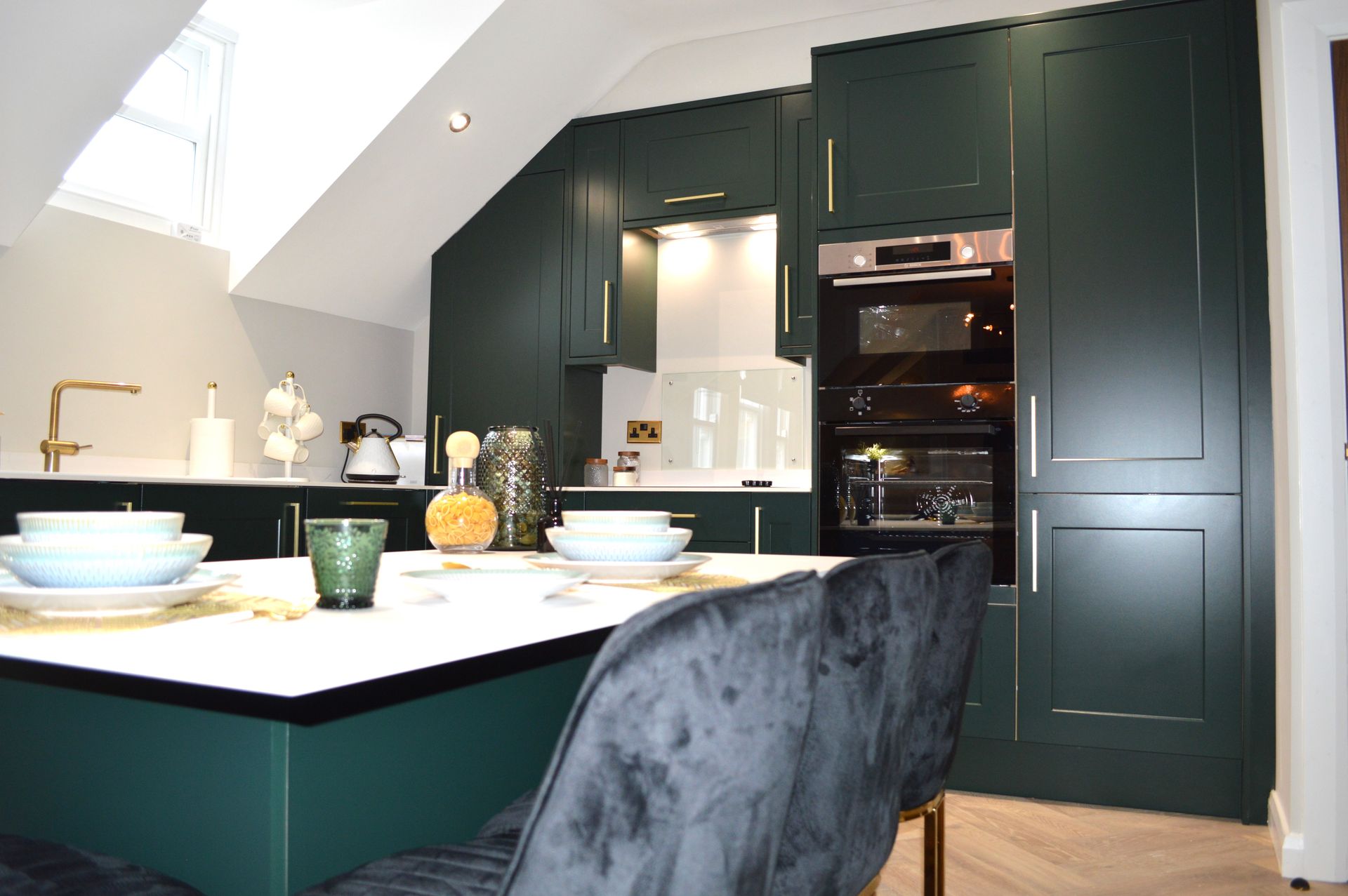 A kitchen with green cabinets , a table and chairs.