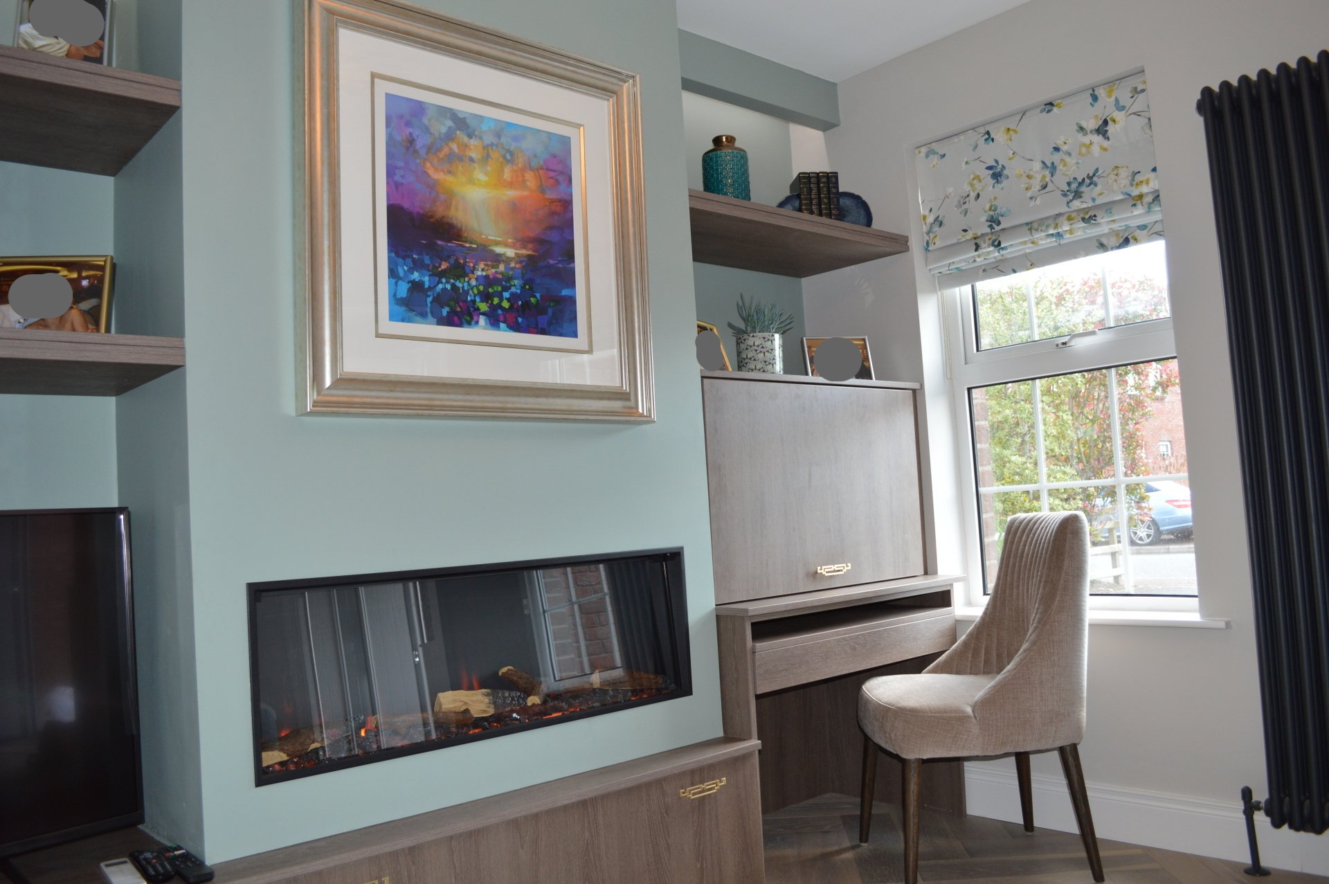 A living room with a fireplace and a painting on the wall.