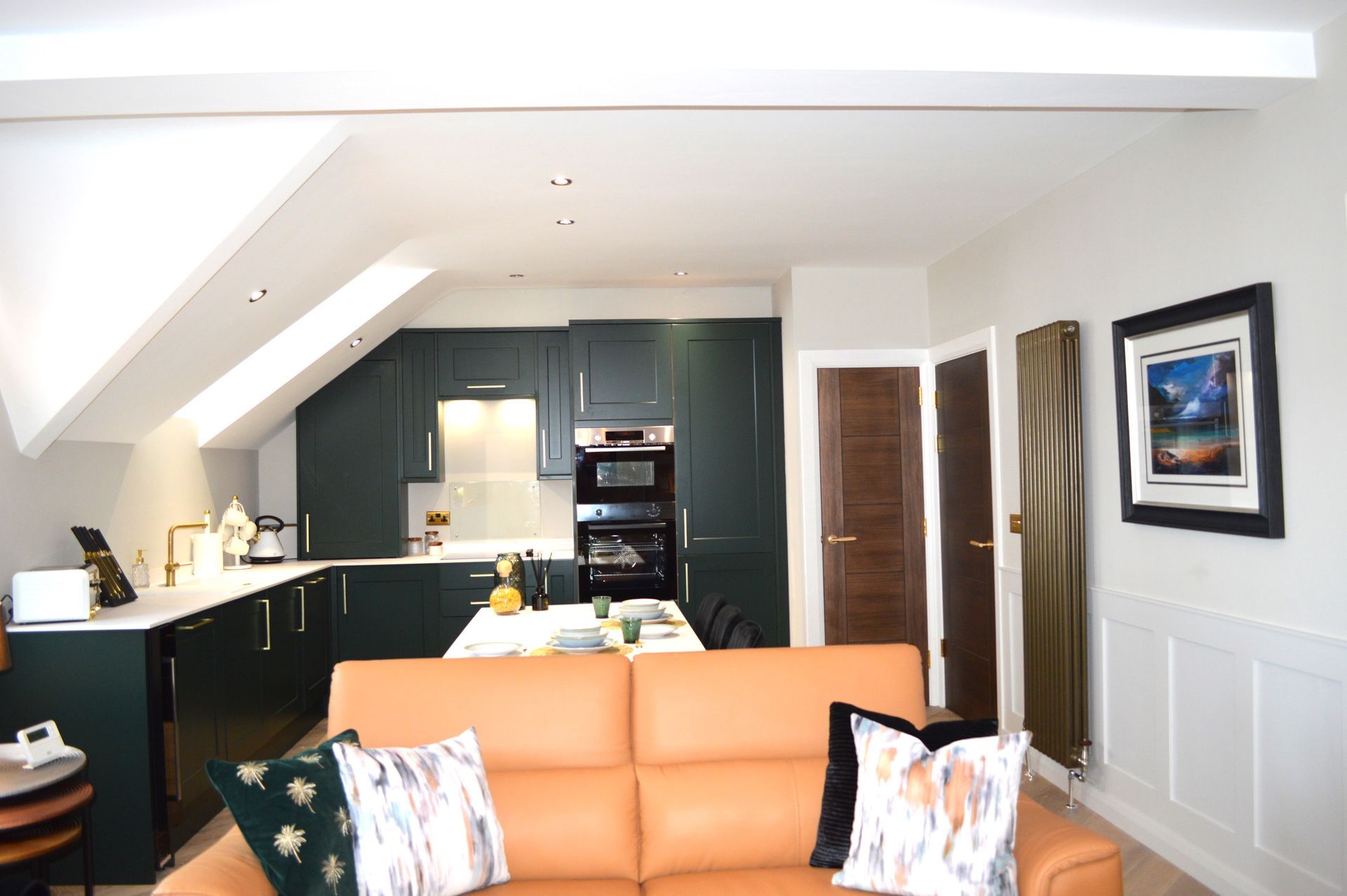 A living room with a couch and a kitchen in the background