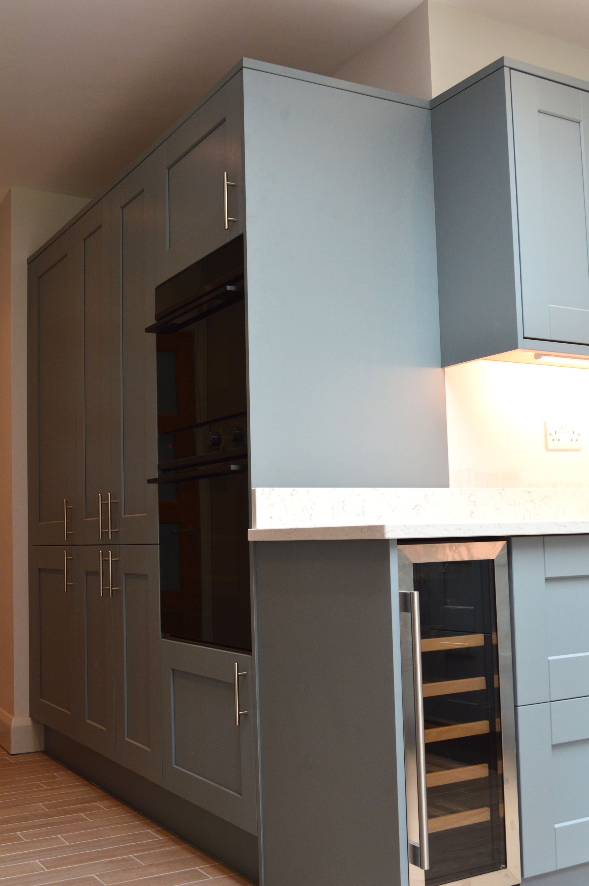 A kitchen with blue cabinets and a wine cooler