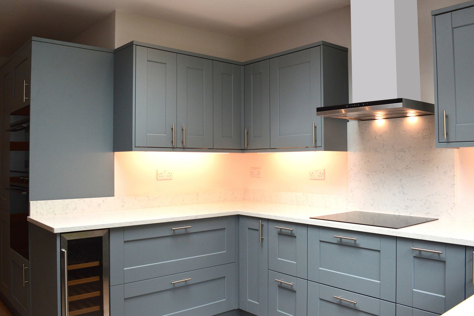 A kitchen with blue cabinets and white counter tops