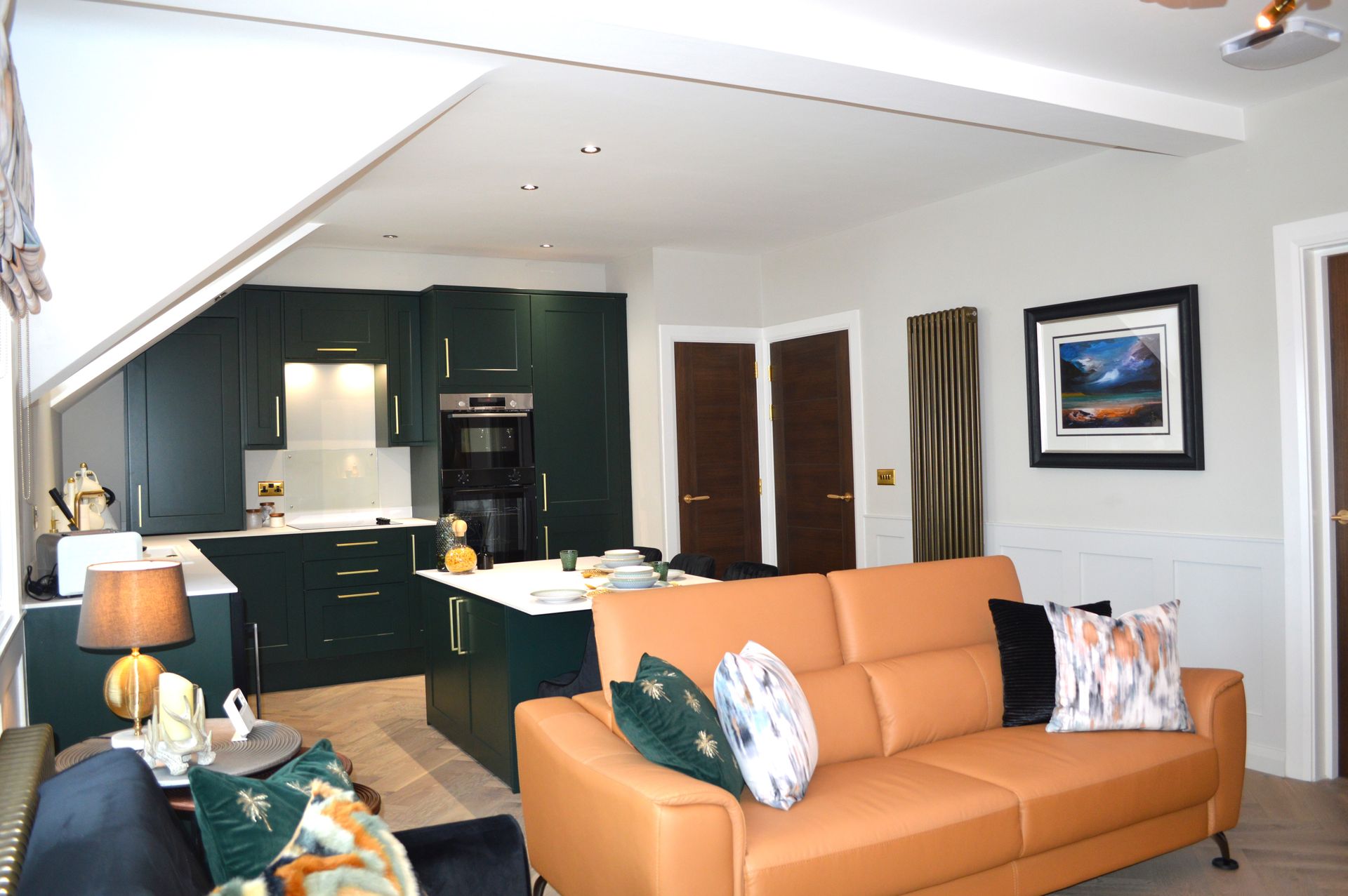 A living room with a couch and a kitchen in the background