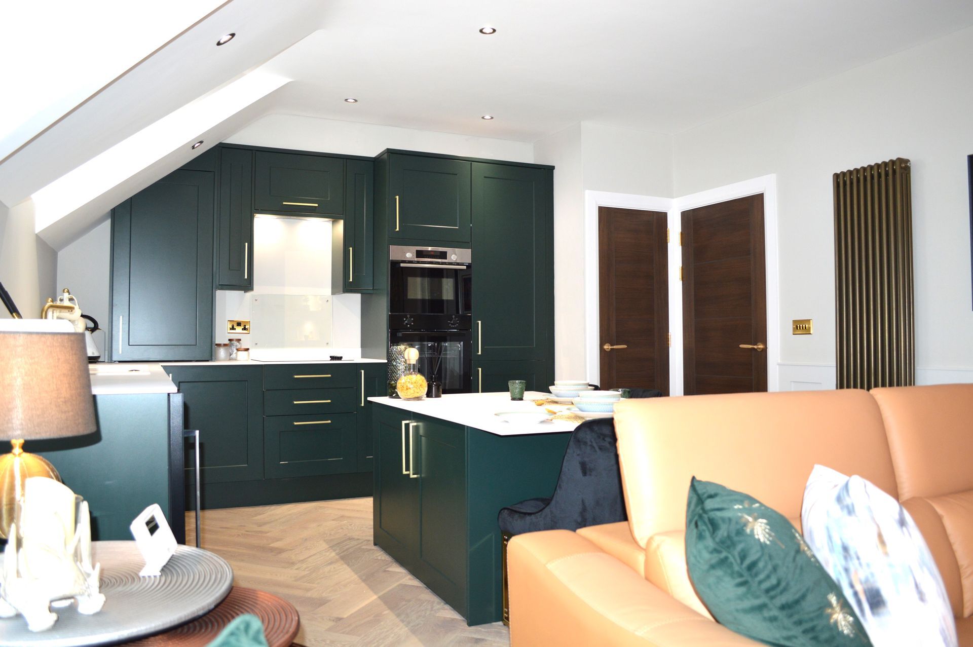 A living room with a couch and a lamp and a kitchen