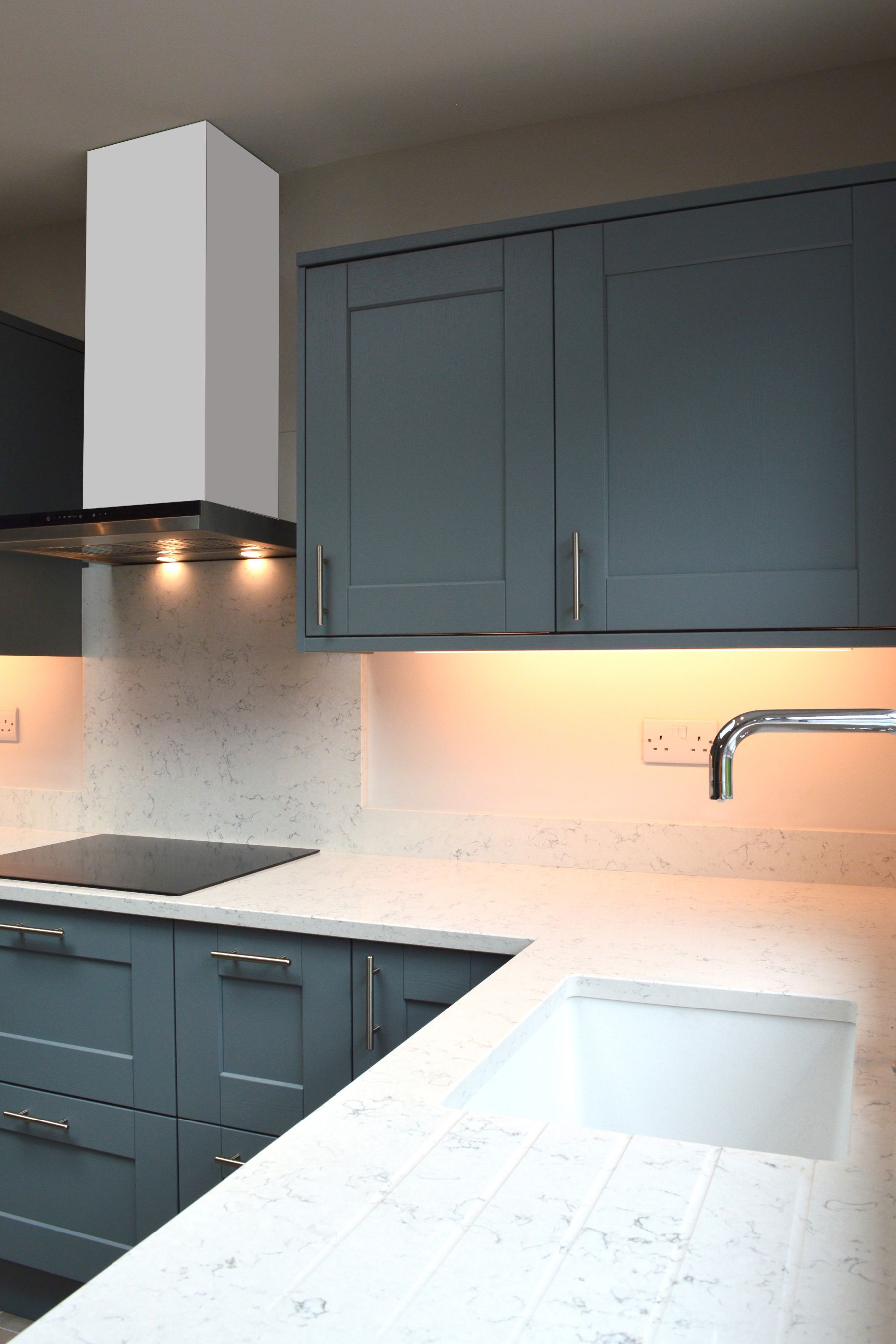 A kitchen with blue cabinets and a white counter top