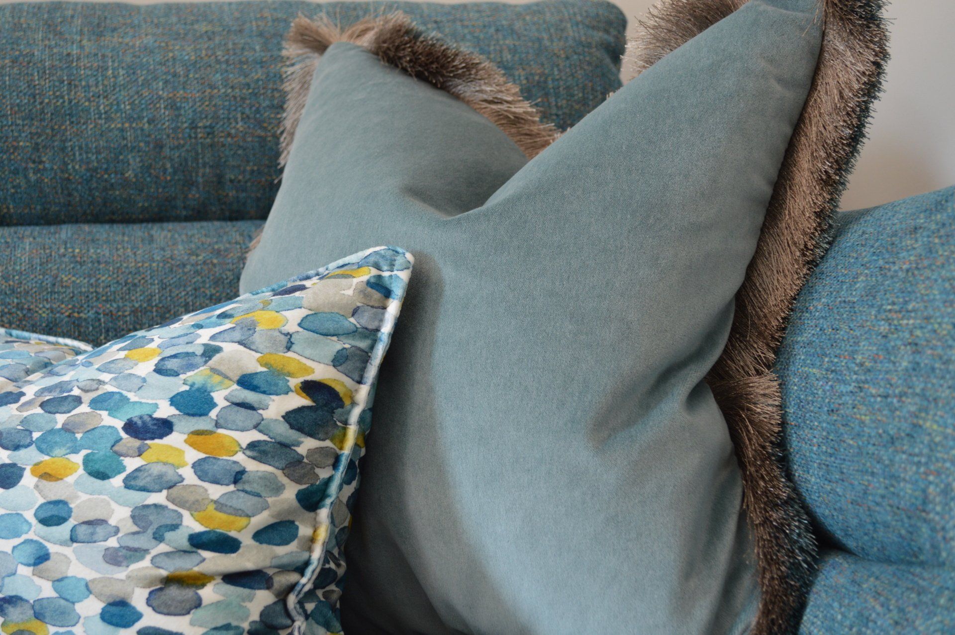 A blue couch with a bunch of pillows on it