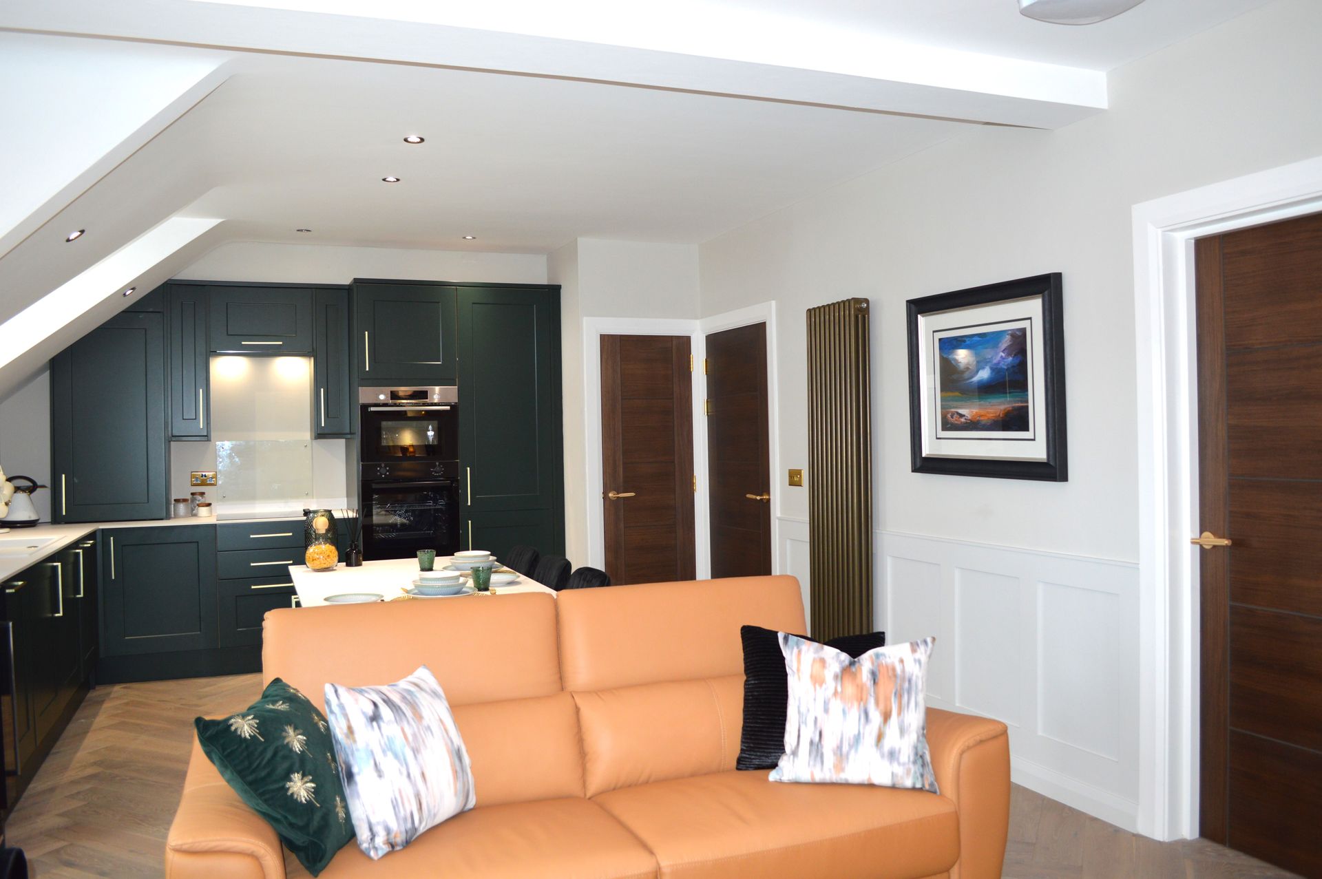 A living room with a couch and a kitchen in the background