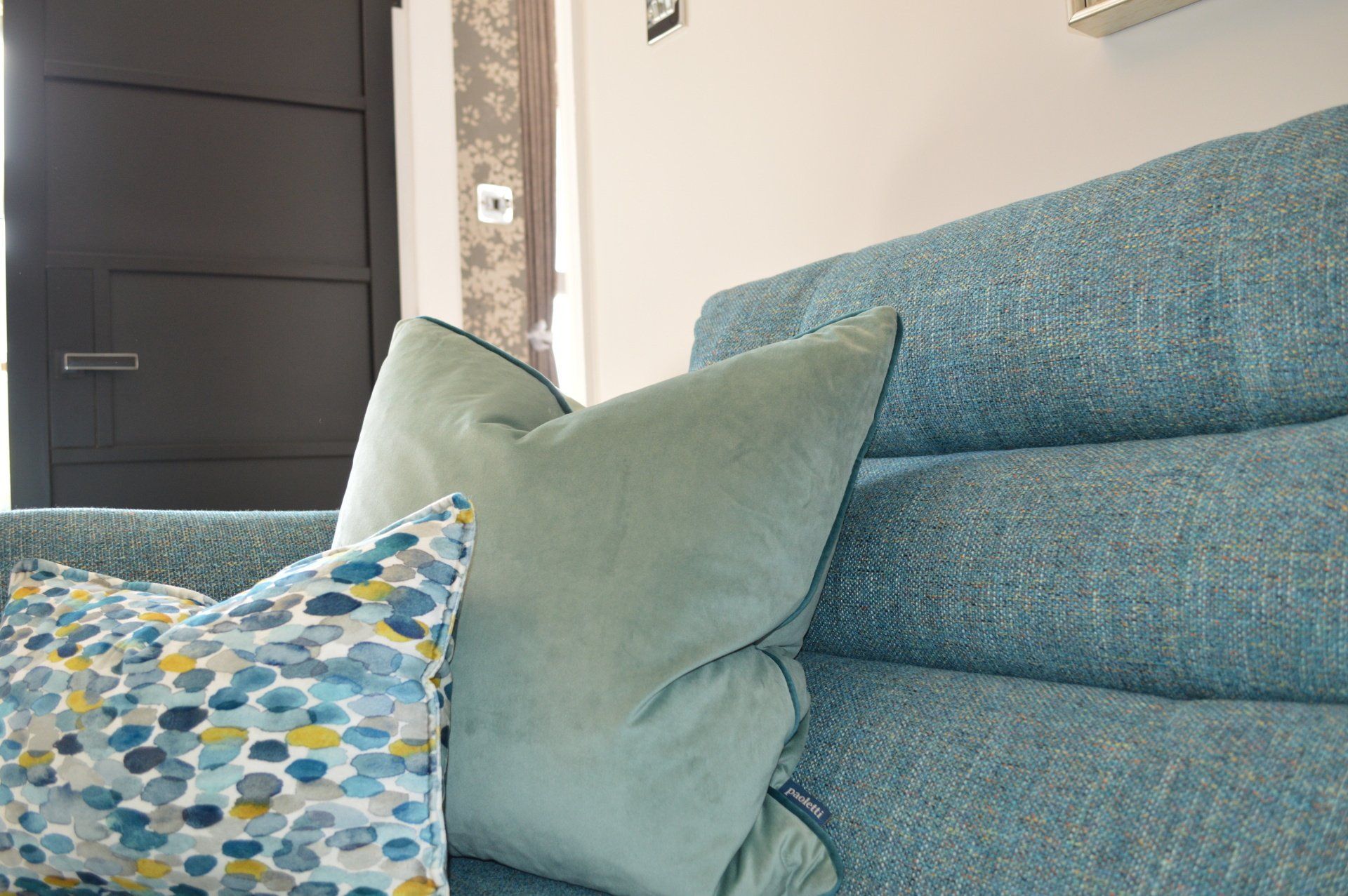A blue couch with two pillows on it in a living room.
