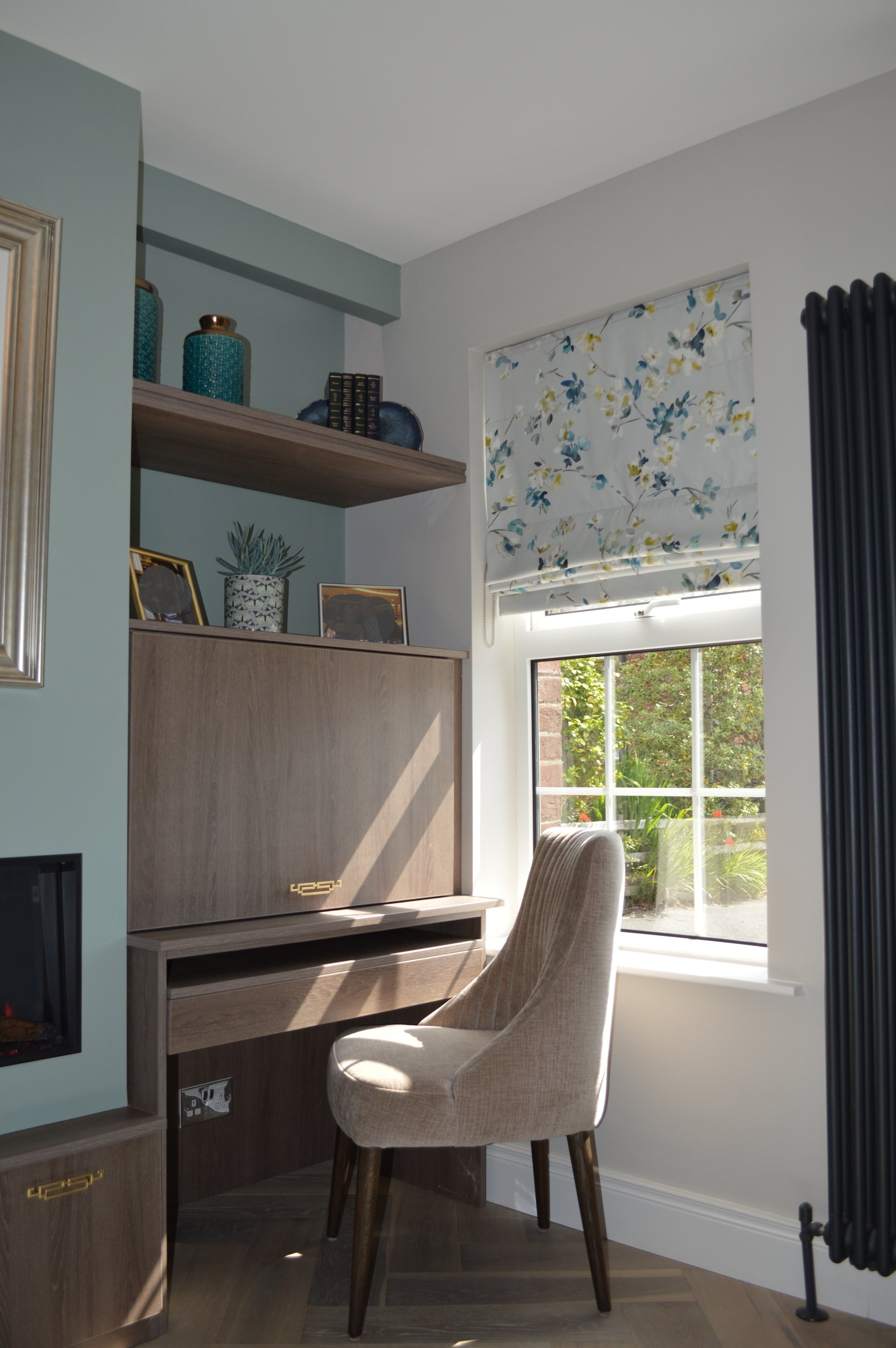 A chair is sitting in front of a desk in a room next to a window.