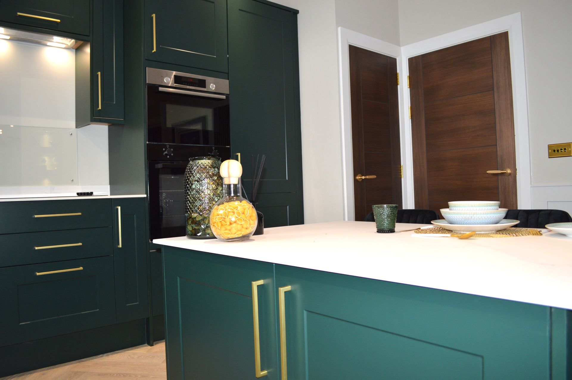 A kitchen with green cabinets and a white counter top.