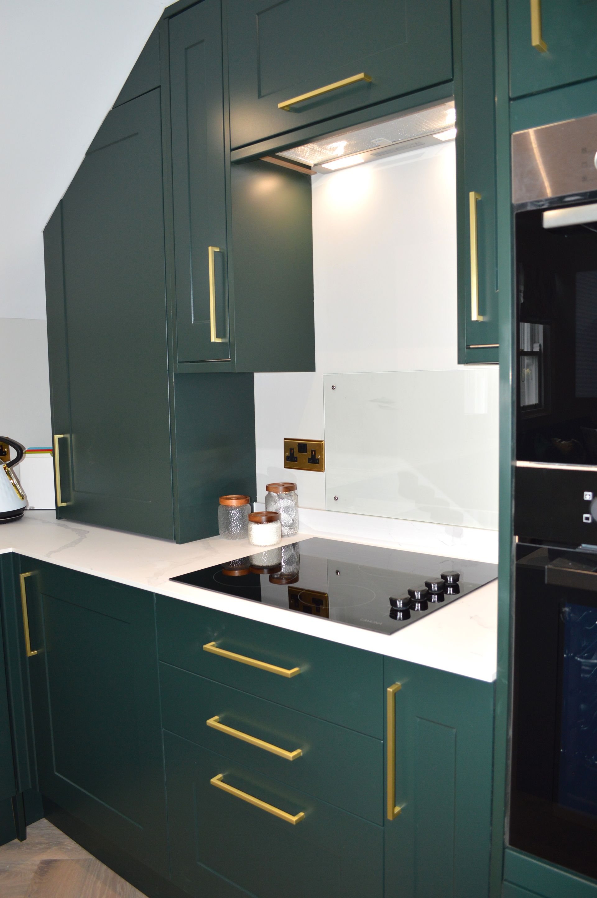 A kitchen with green cabinets and a stove top oven.