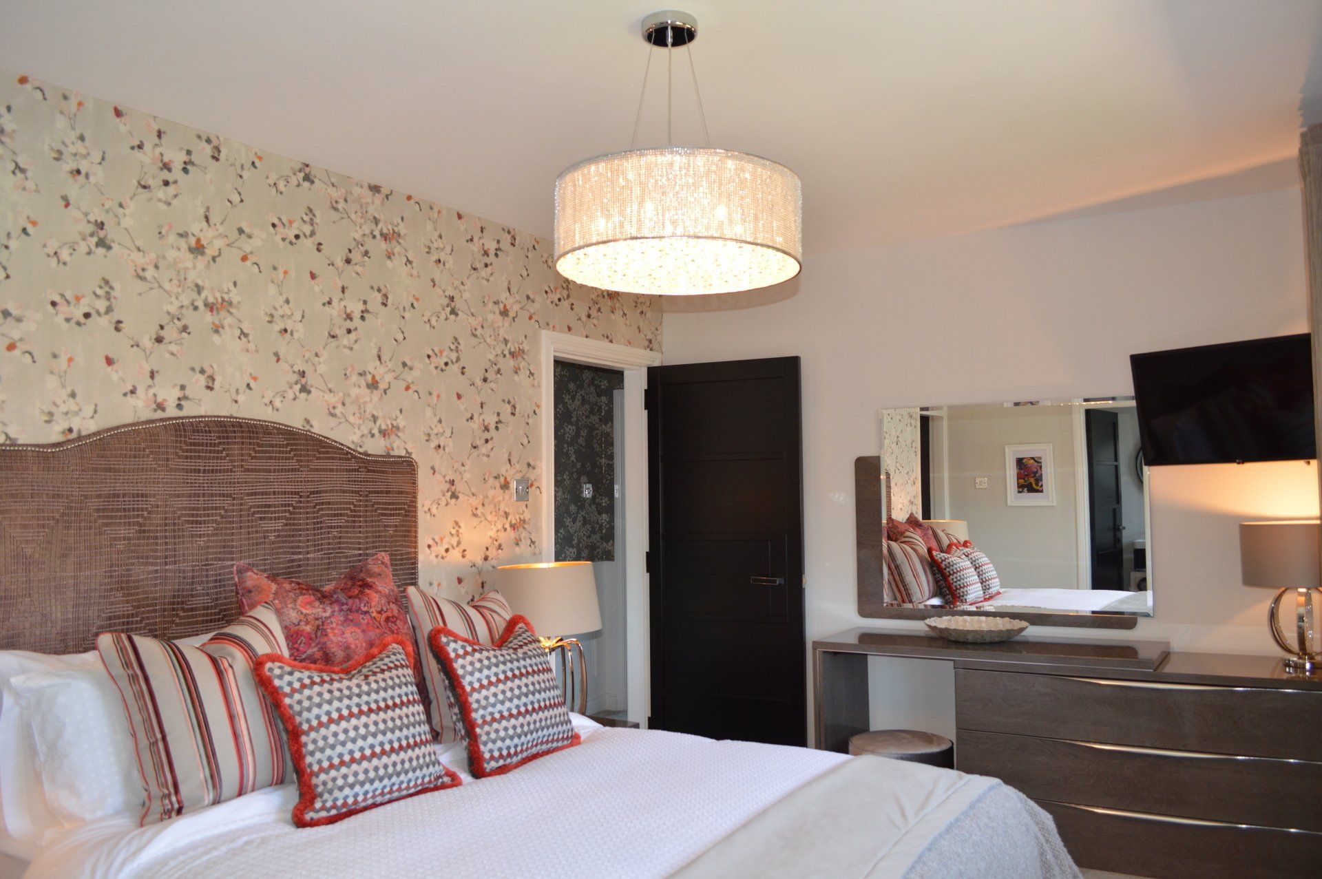 A bedroom with a large bed and a mirror