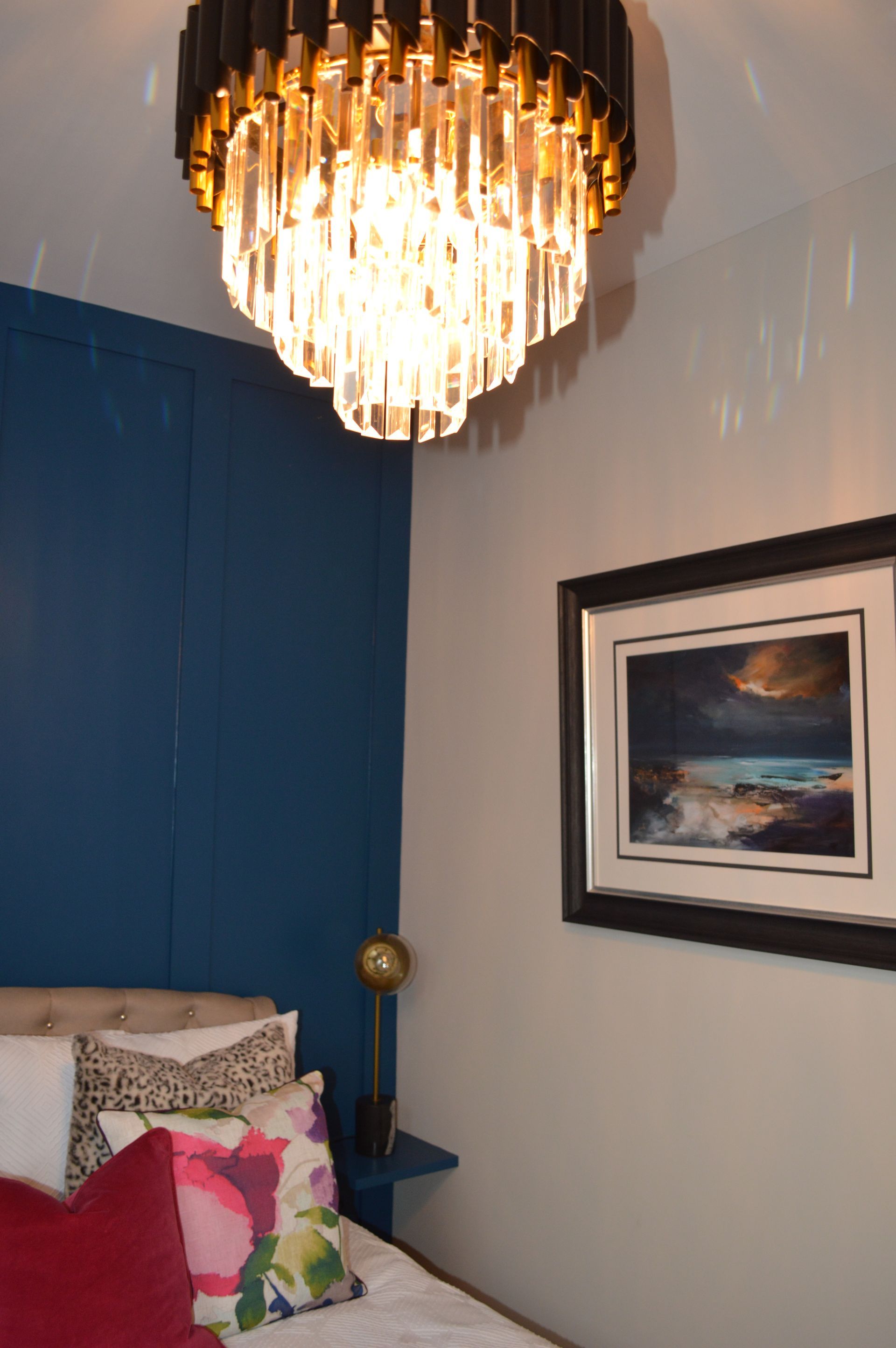 A bedroom with a bed and a chandelier hanging from the ceiling