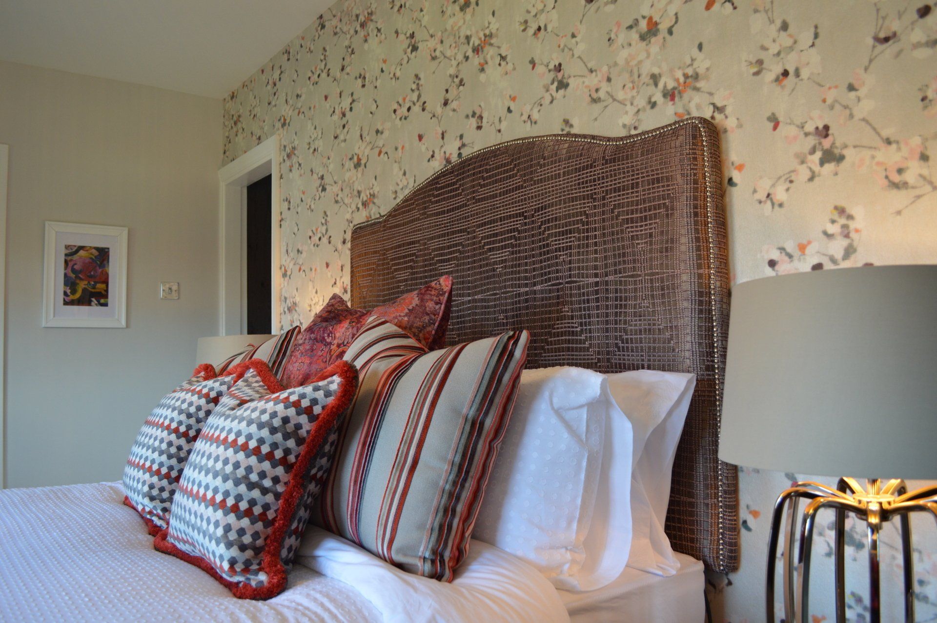 A bed with a headboard and pillows in a bedroom.