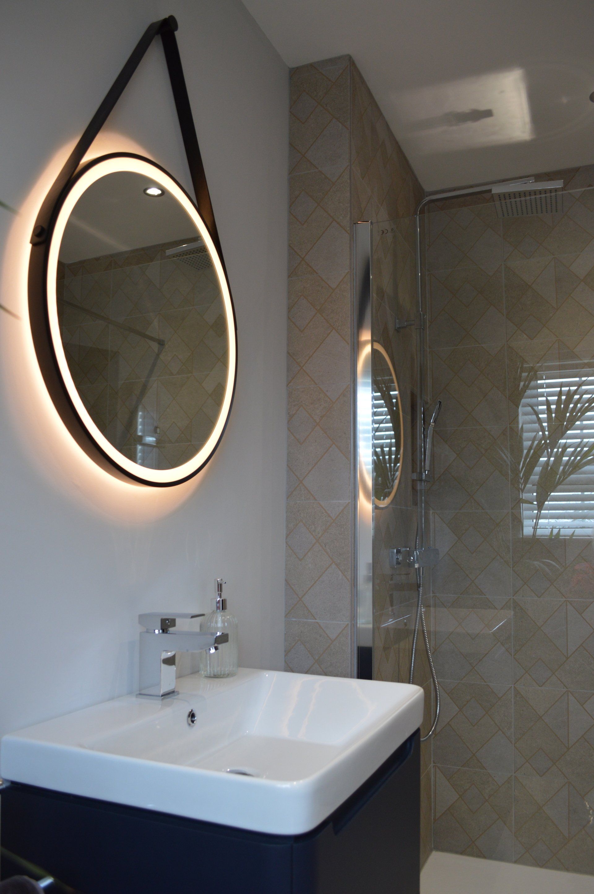 A bathroom with a sink and a round mirror