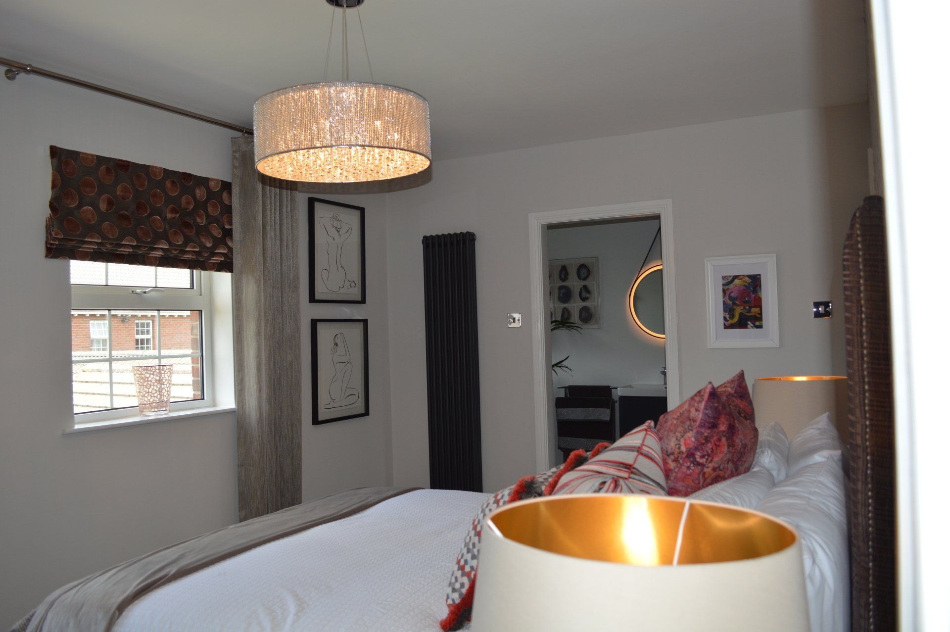 A bedroom with a large bed and a lamp