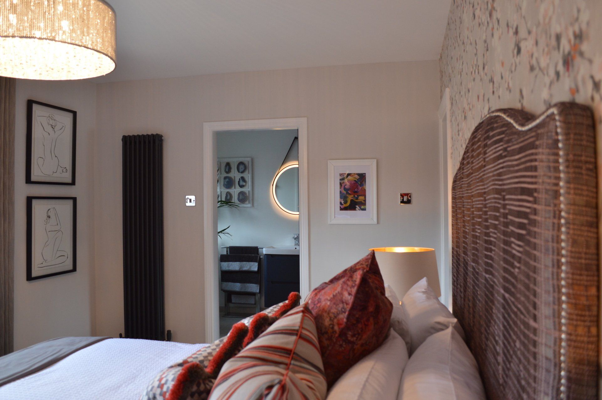 A bedroom with a large bed and a lamp.