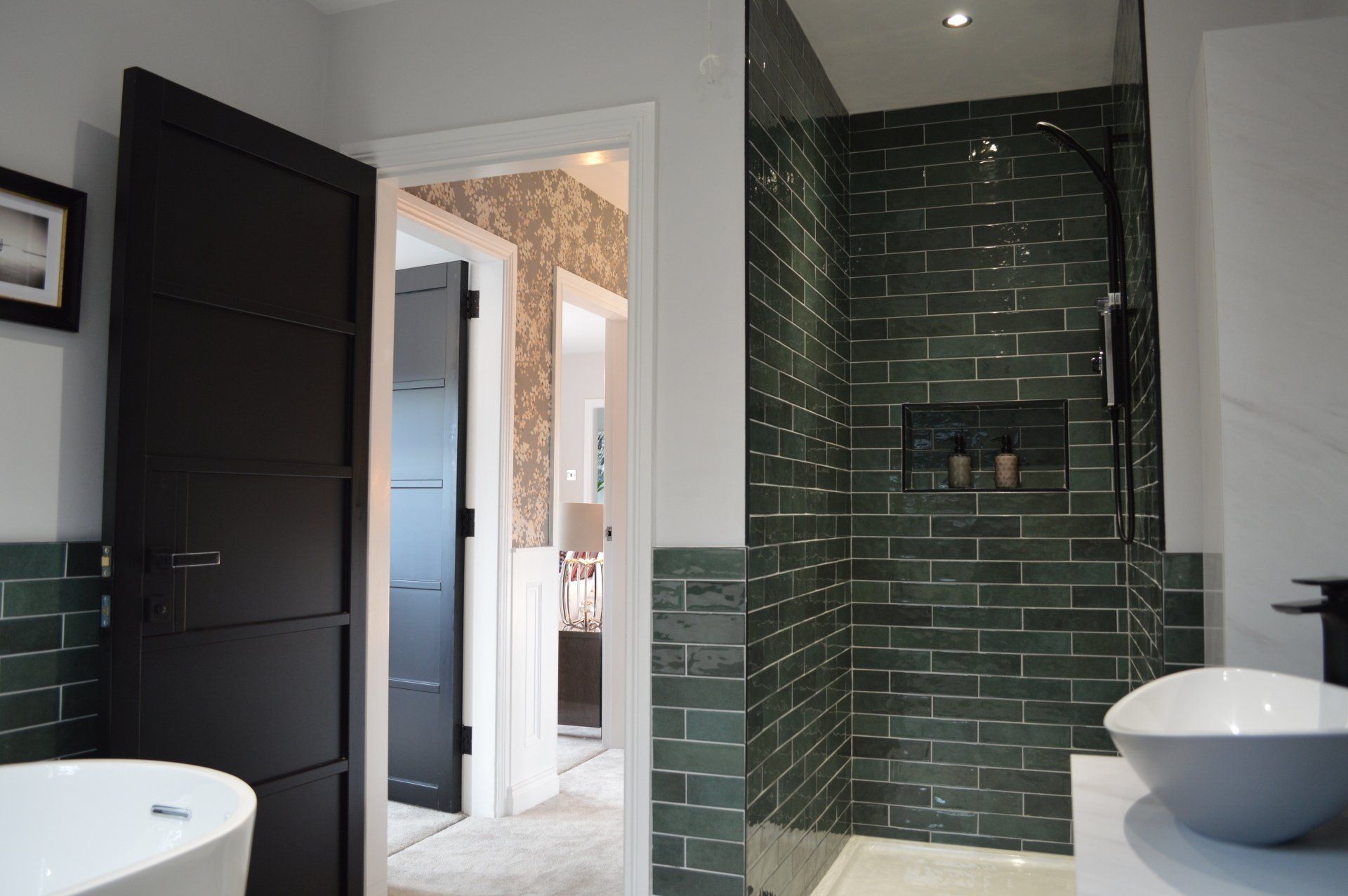 A bathroom with green tiles and a walk in shower