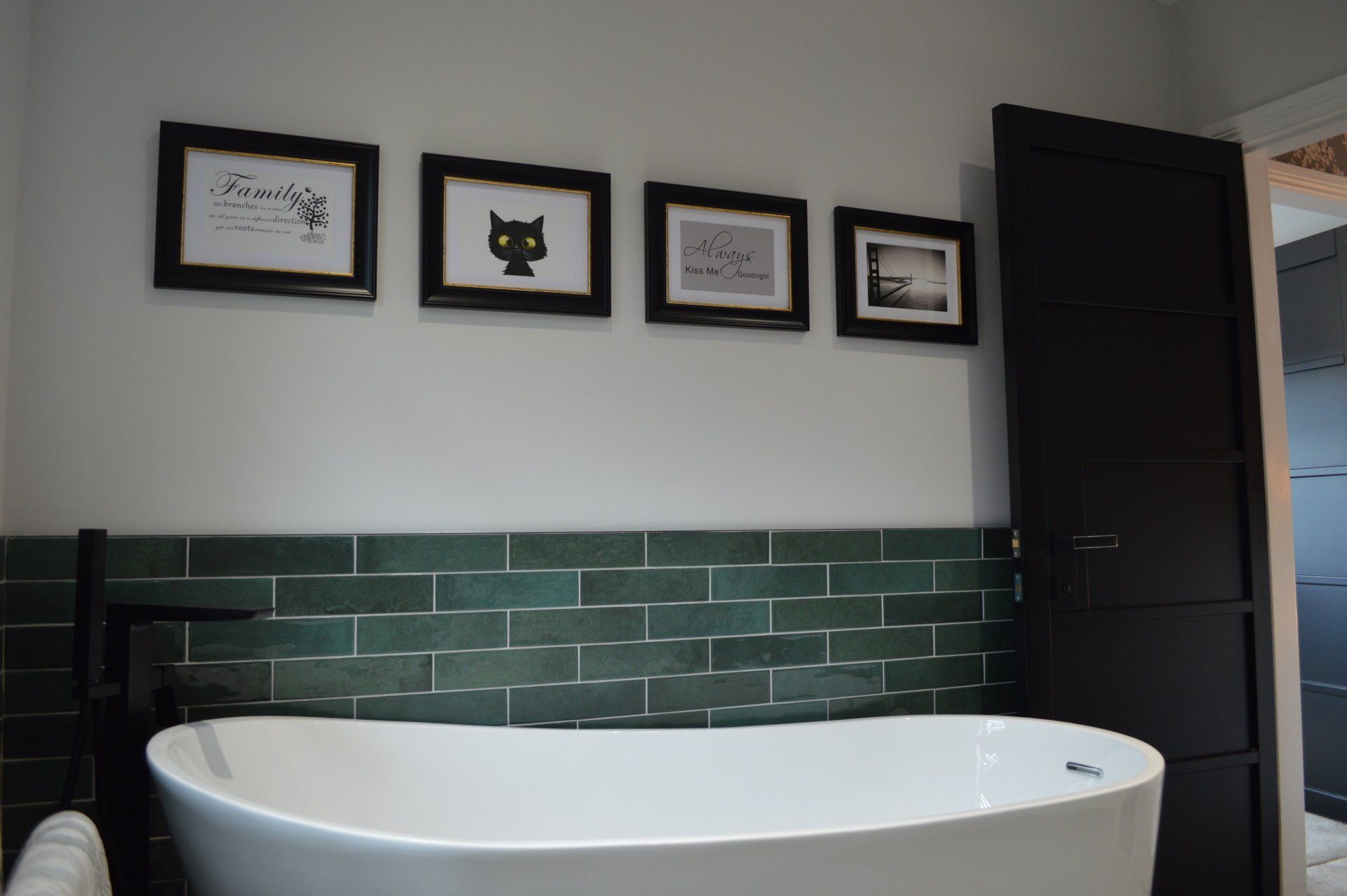A bathroom with a bathtub and pictures on the wall