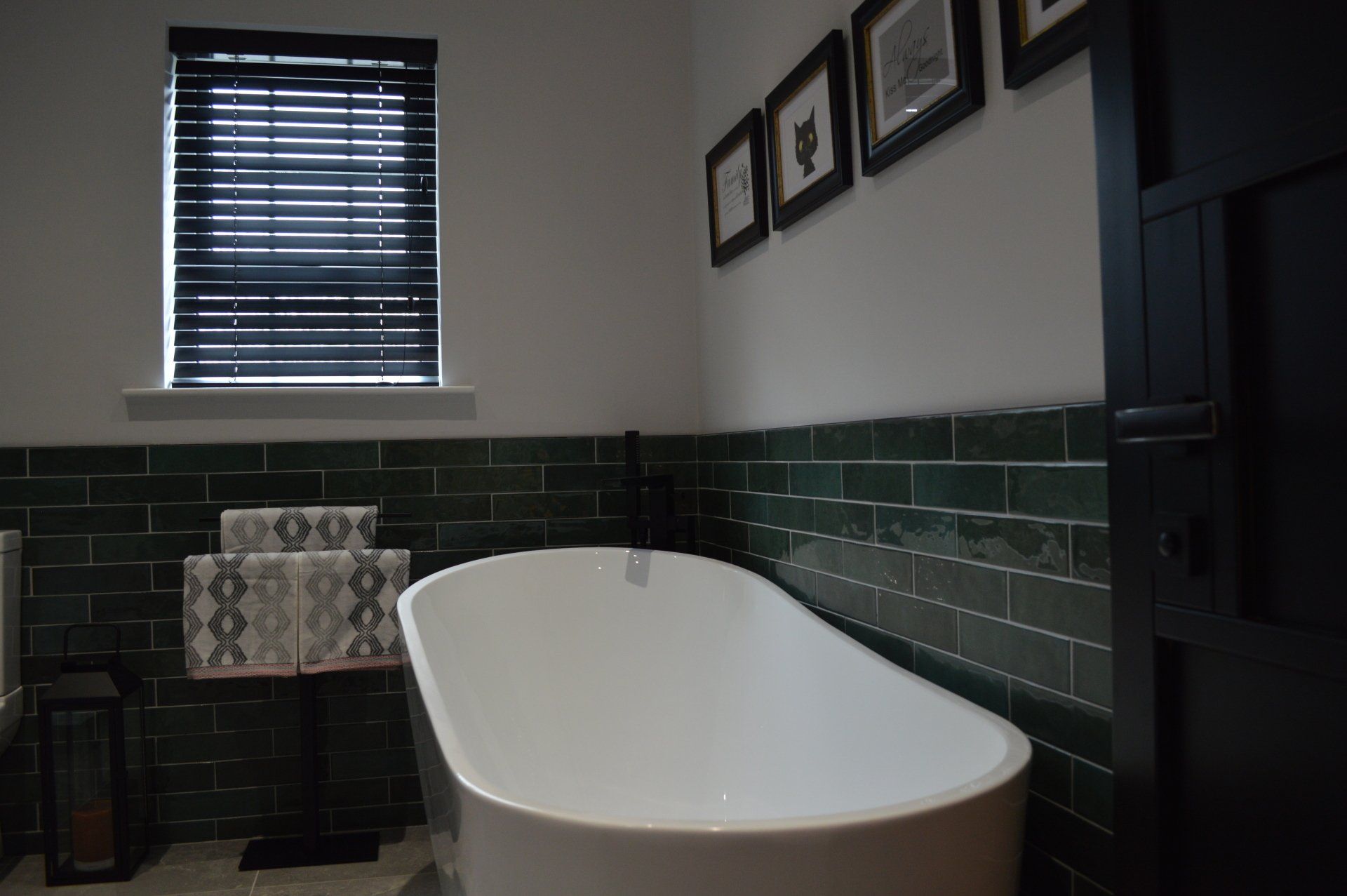 A bathroom with a bathtub and a window with blinds.