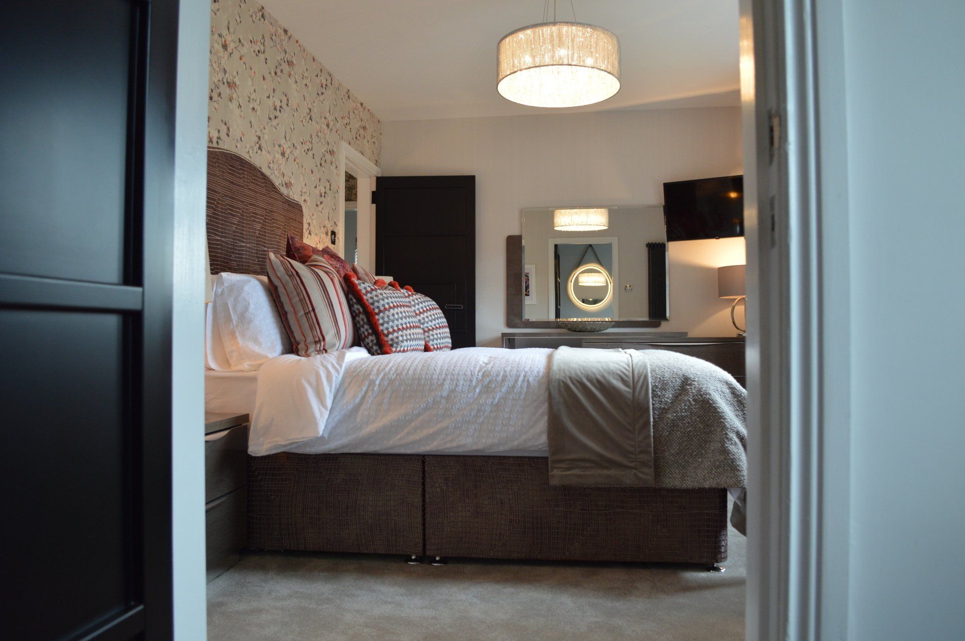 A bedroom with a large bed and a mirror