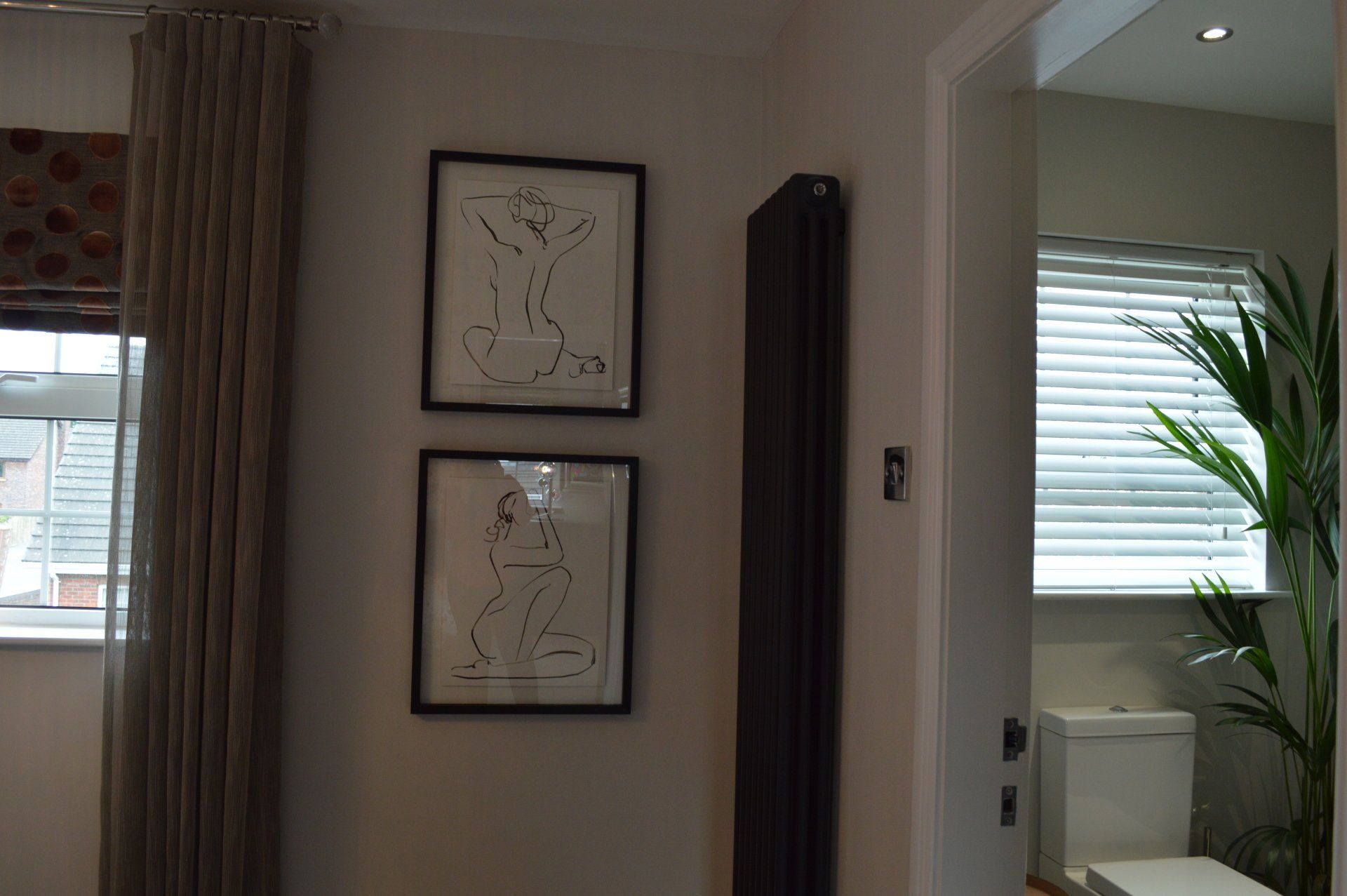 A bathroom with a toilet and two pictures on the wall