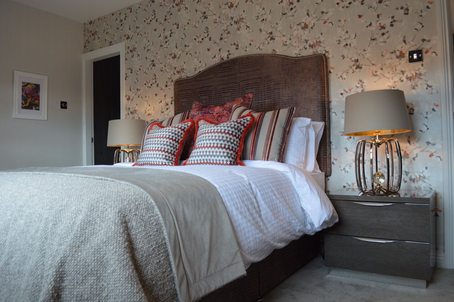 A bedroom with a large bed and two lamps