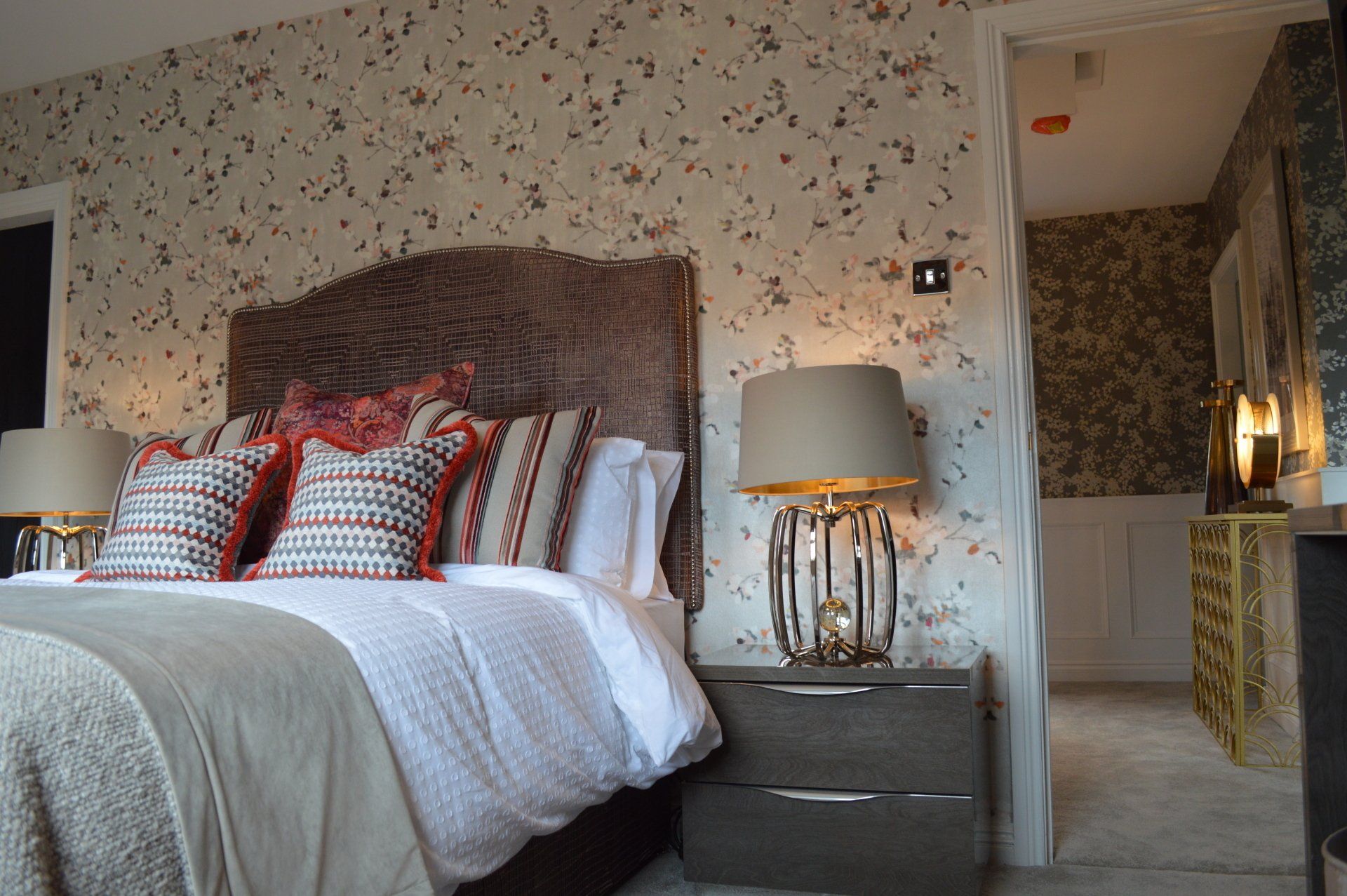 A bedroom with a large bed and two lamps