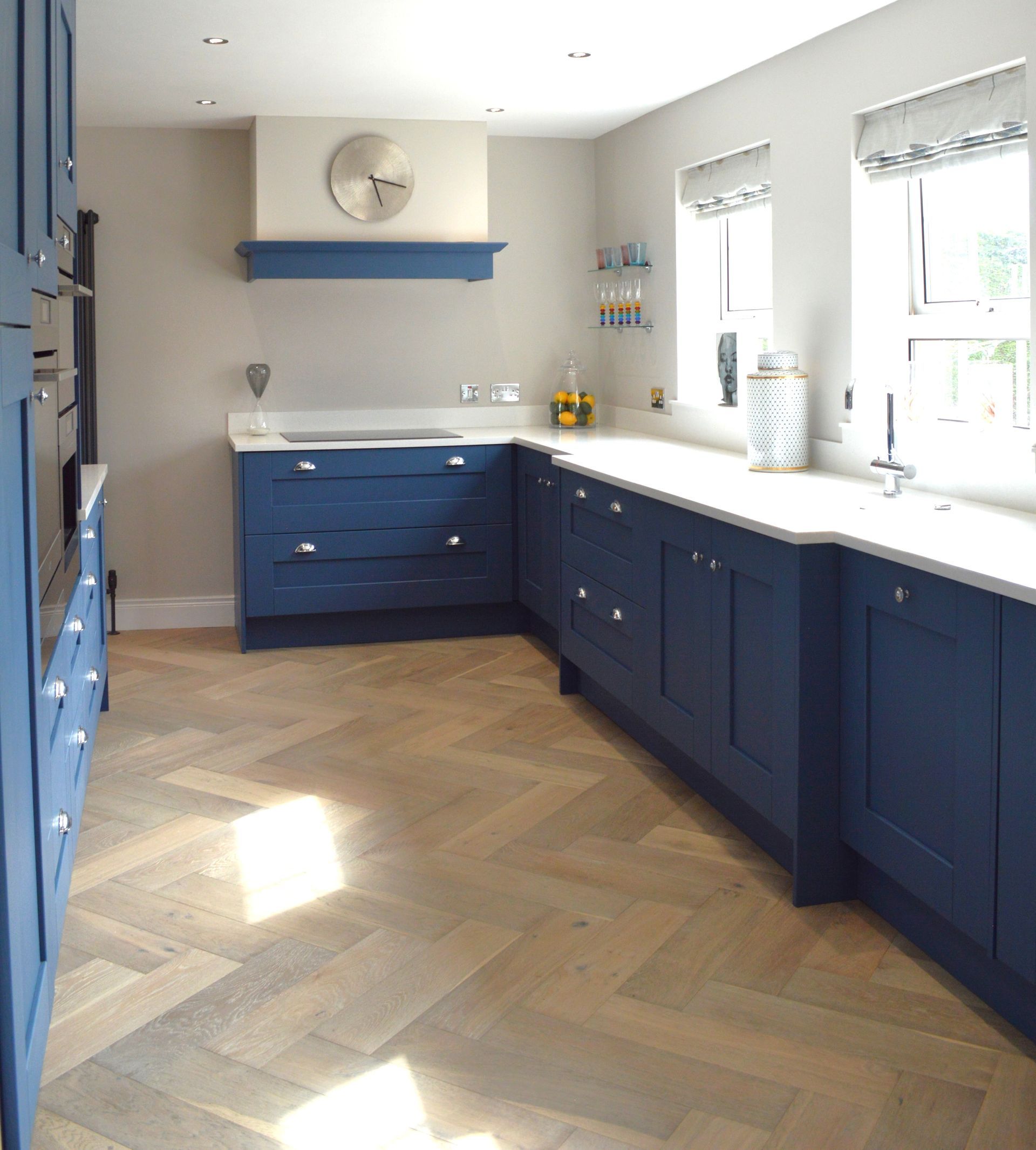 A kitchen with blue cabinets and white counter tops