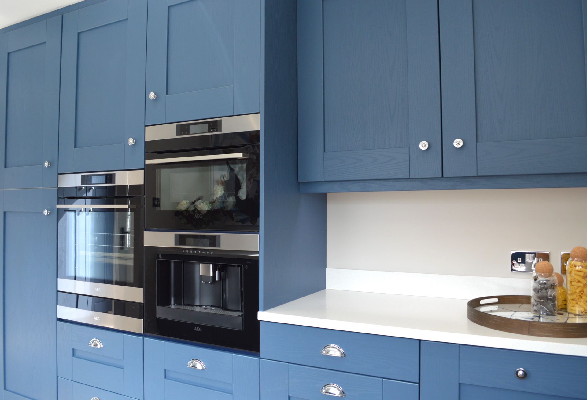 A kitchen with blue cabinets and stainless steel appliances.