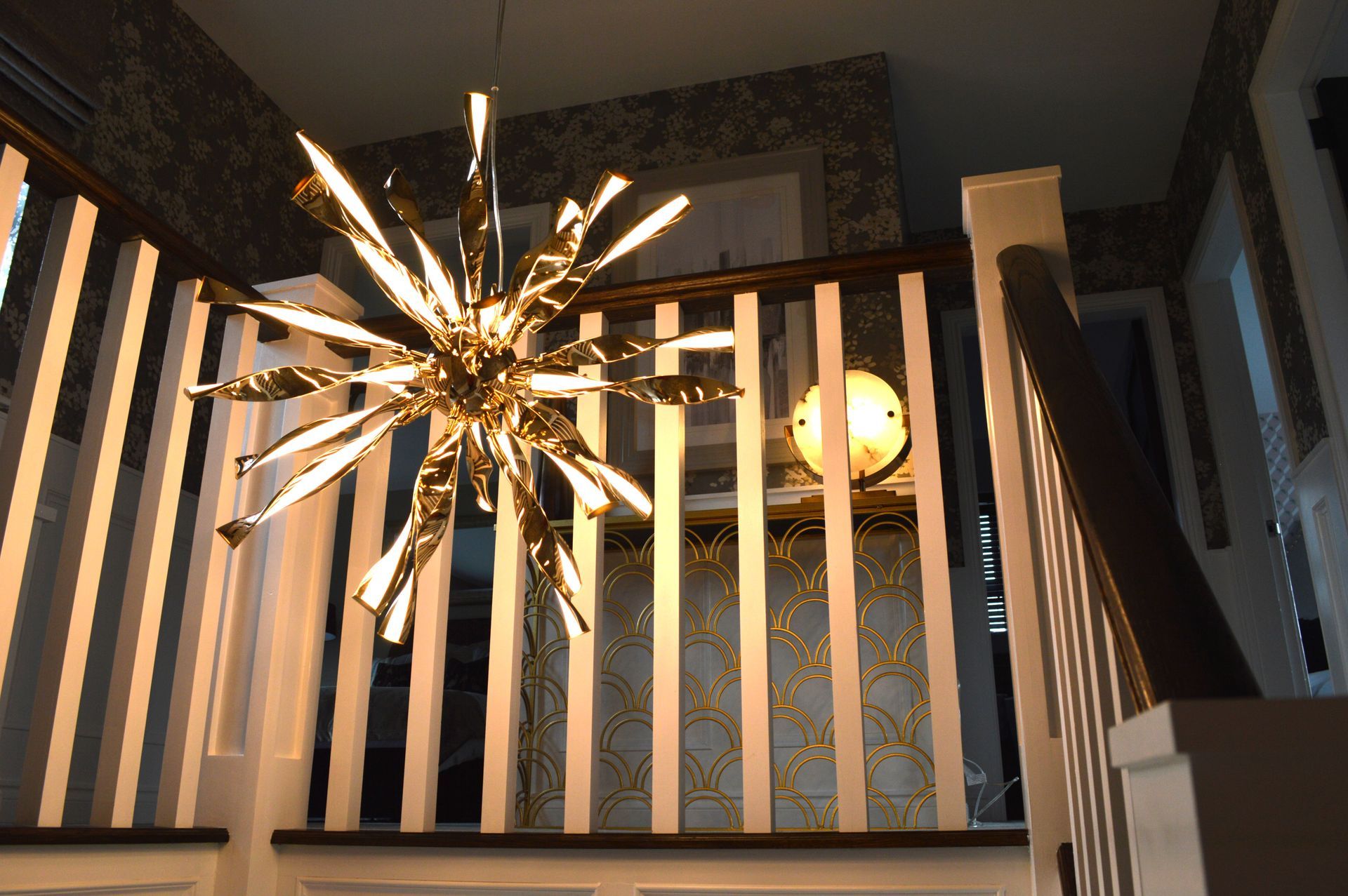 A staircase with a chandelier hanging from the ceiling