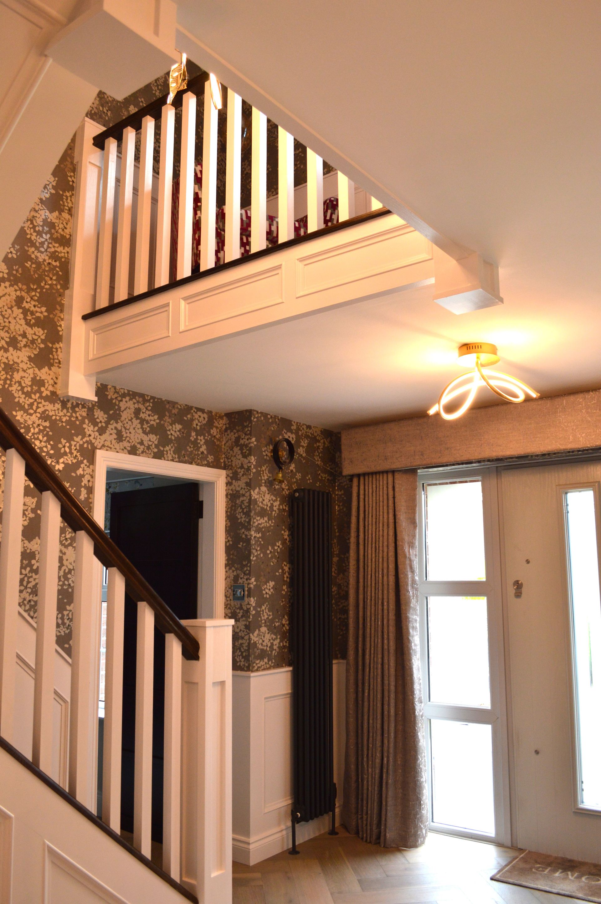 A hallway with a staircase leading up to the second floor