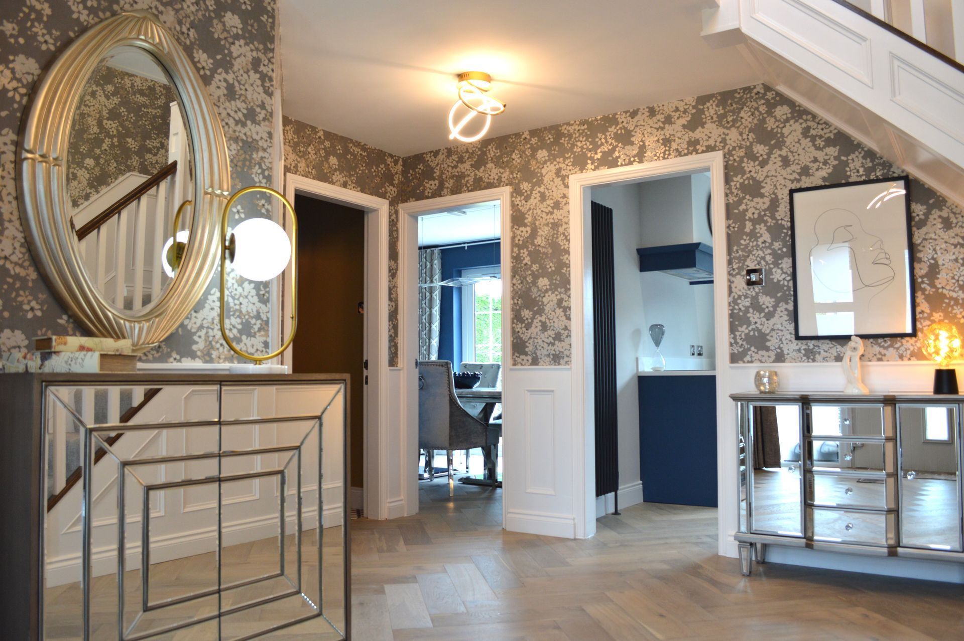 A hallway with a mirror and a staircase in a house.