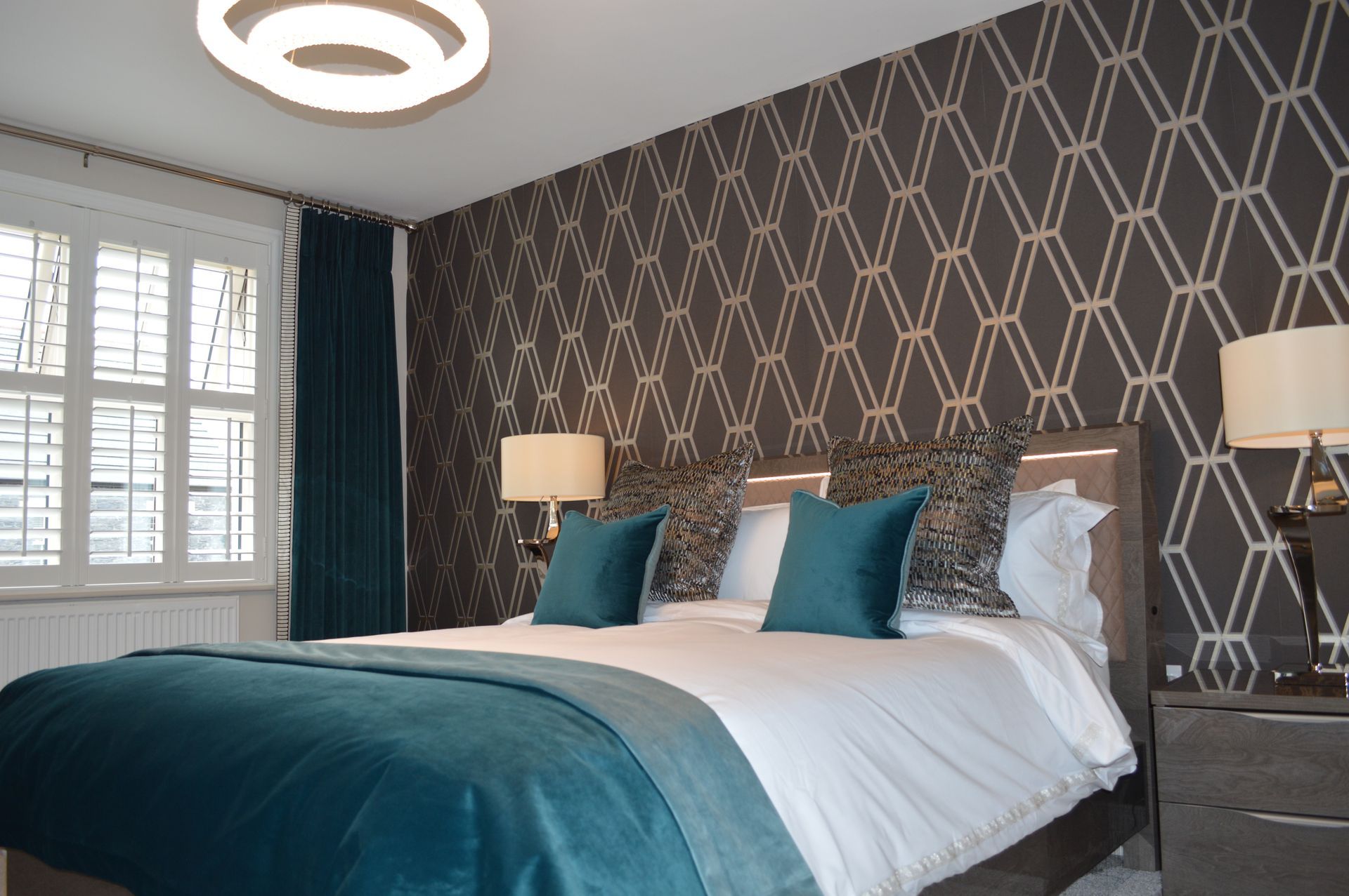 A bedroom with a bed , nightstand and lamps