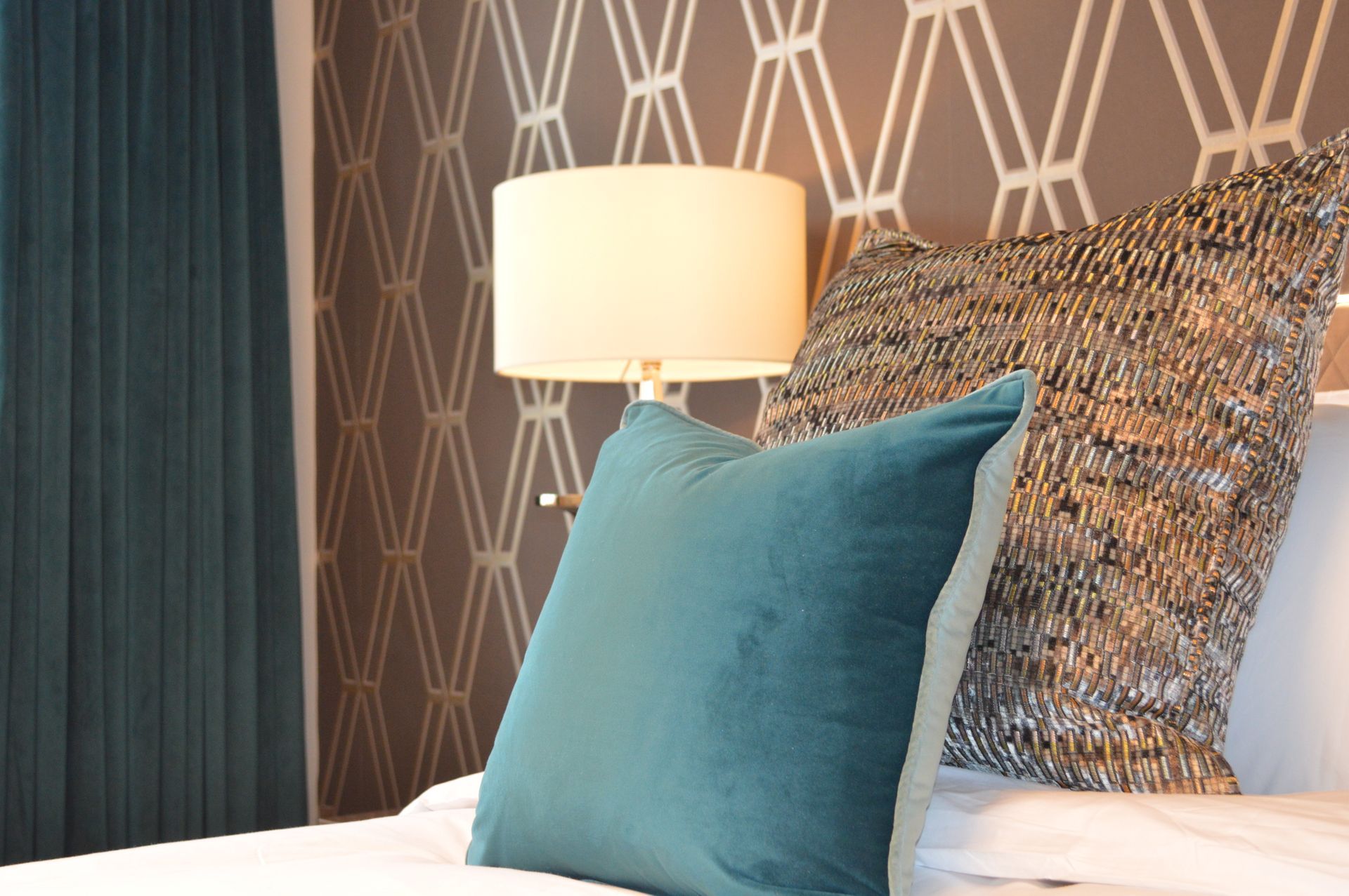 A bed with a lamp and pillows on it