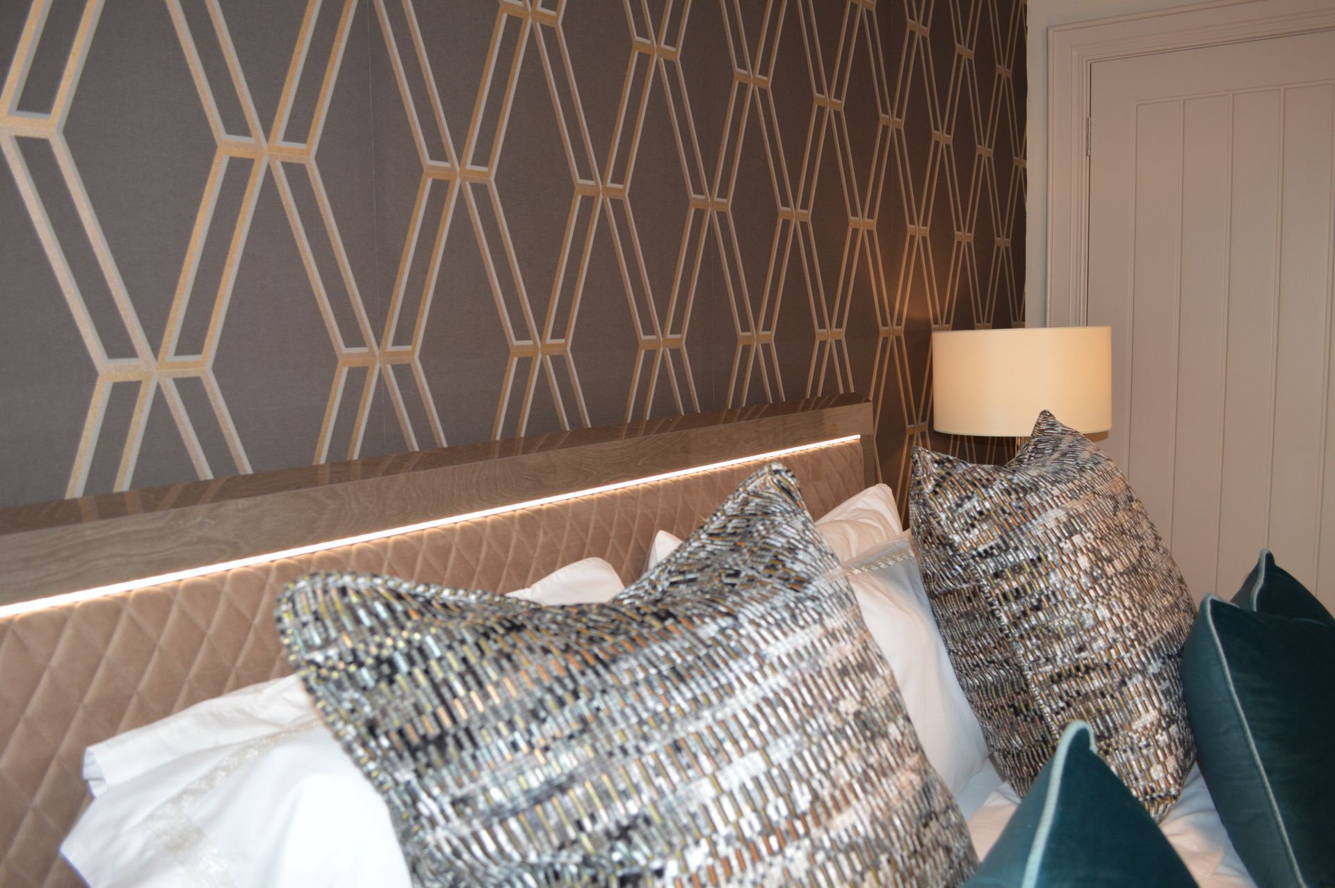 A bed with pillows and a lamp in a bedroom