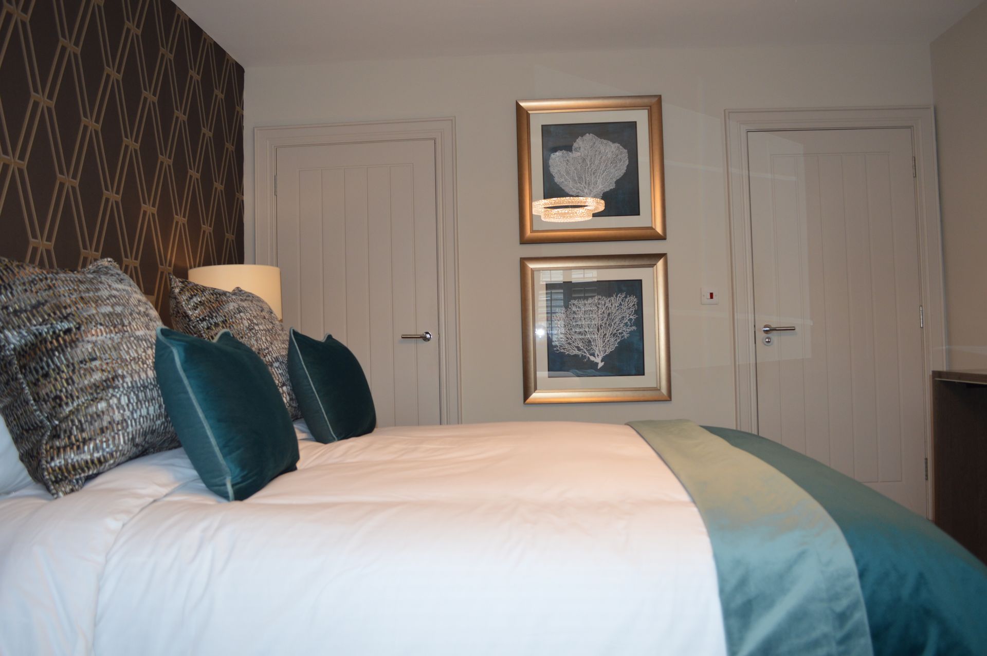 A bedroom with a bed and two pictures on the wall