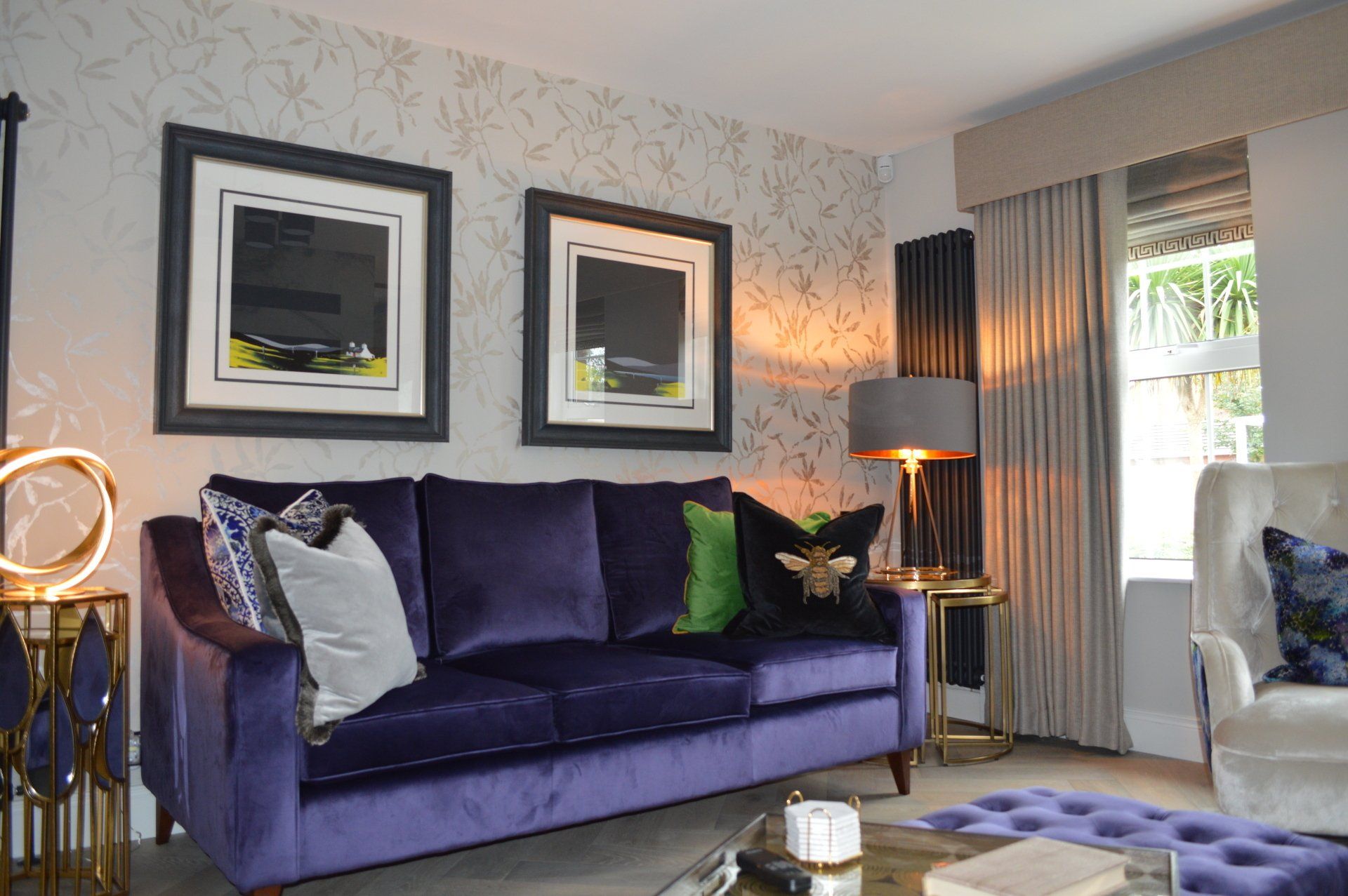 A living room with a purple couch and a white chair.