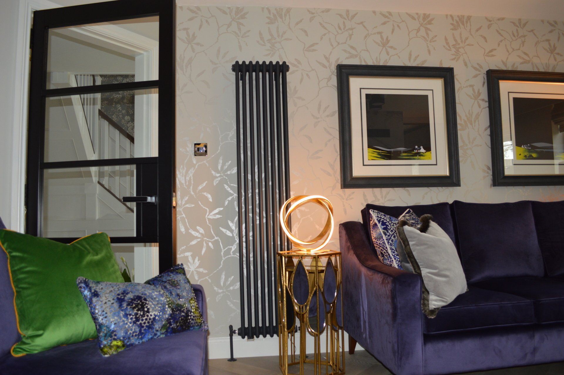 A living room with a purple couch and green pillows