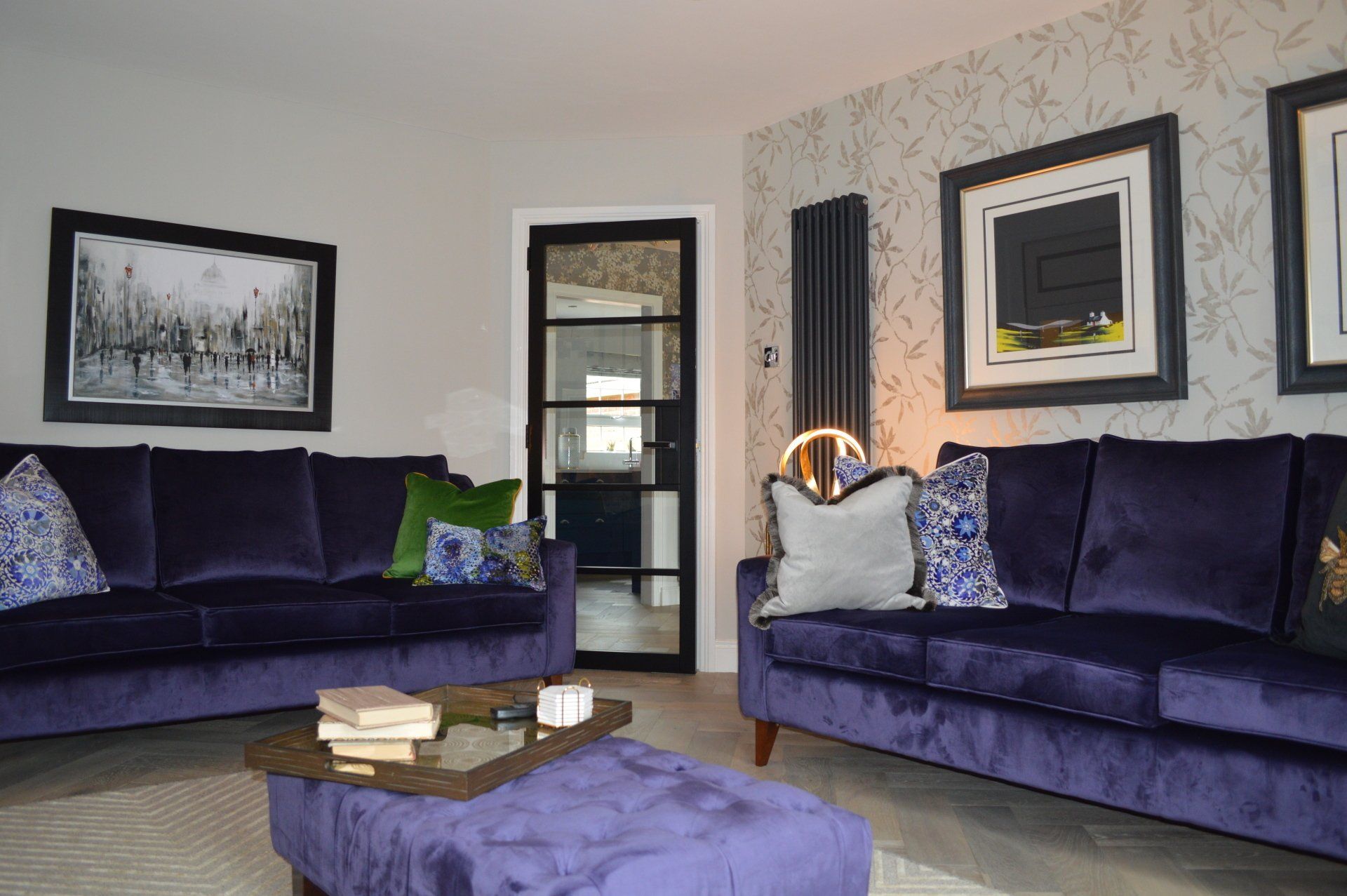 A living room with two purple couches and a purple ottoman.