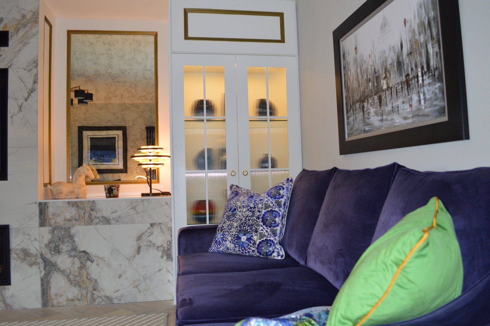 A living room with a purple couch and green pillows