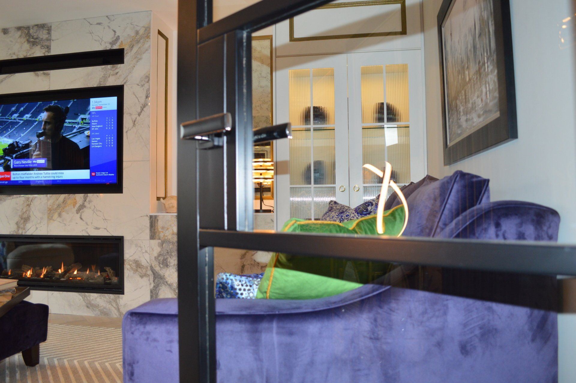 A living room with a purple couch and a flat screen tv
