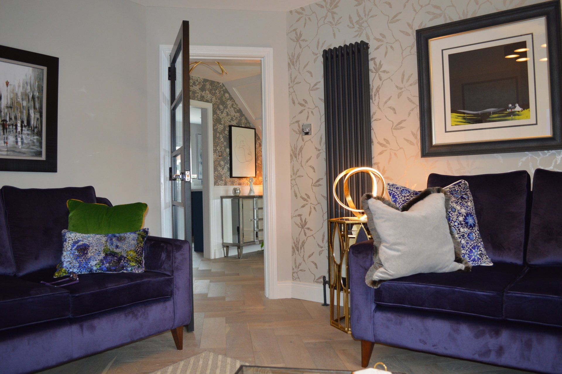 A living room with two purple couches and a table.