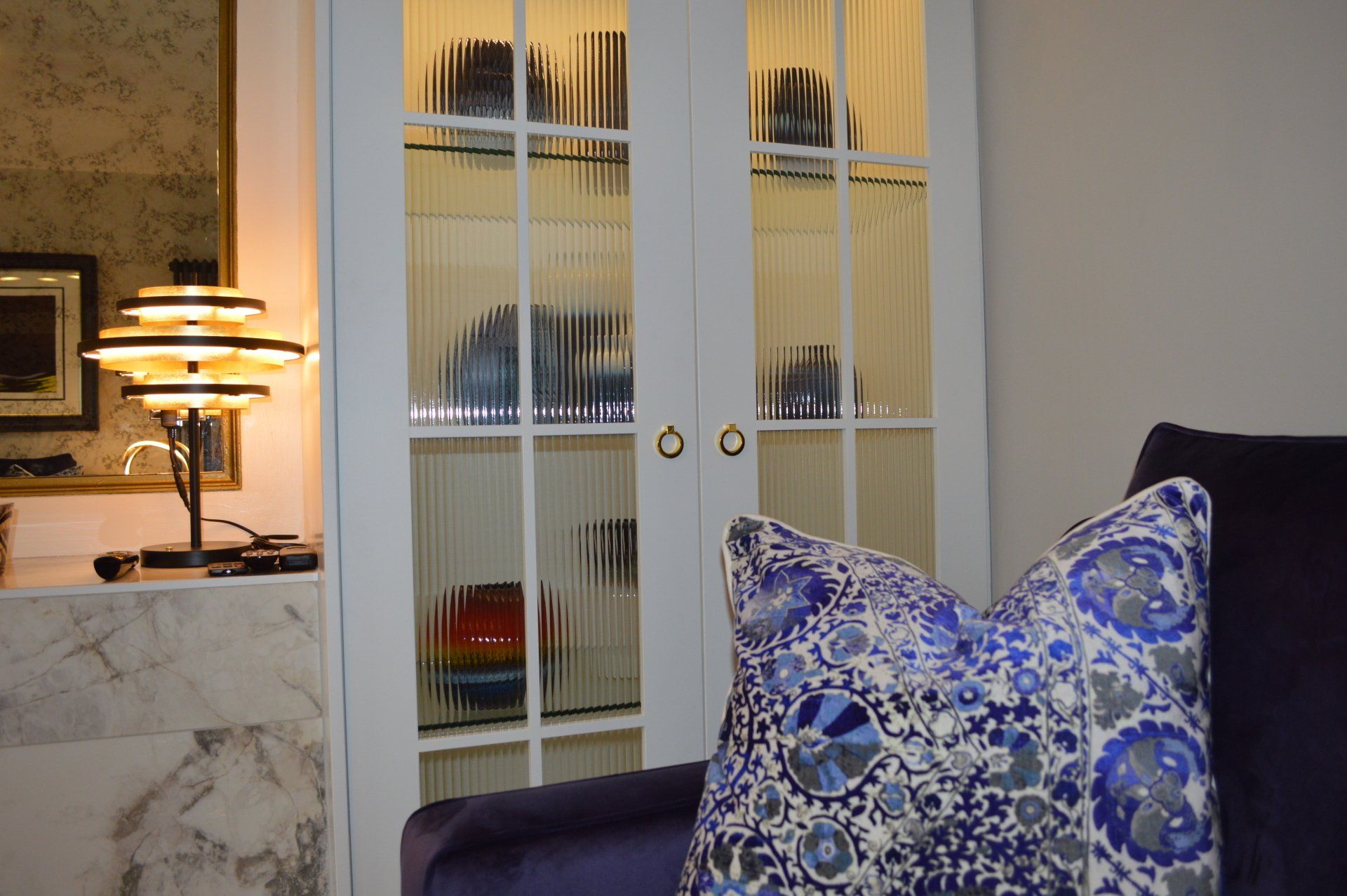 A living room with a purple couch and a blue pillow