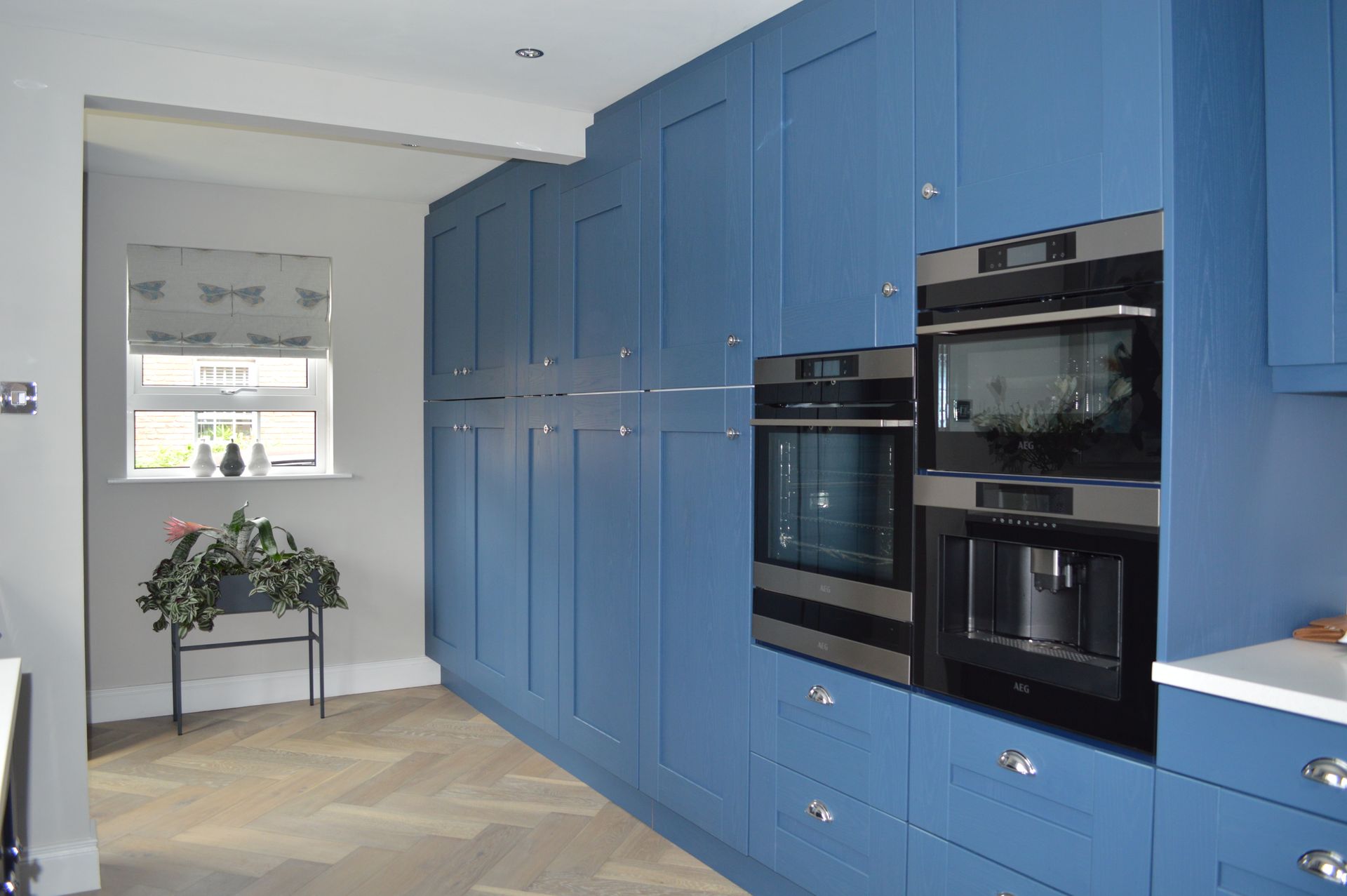A kitchen with blue cabinets and stainless steel appliances
