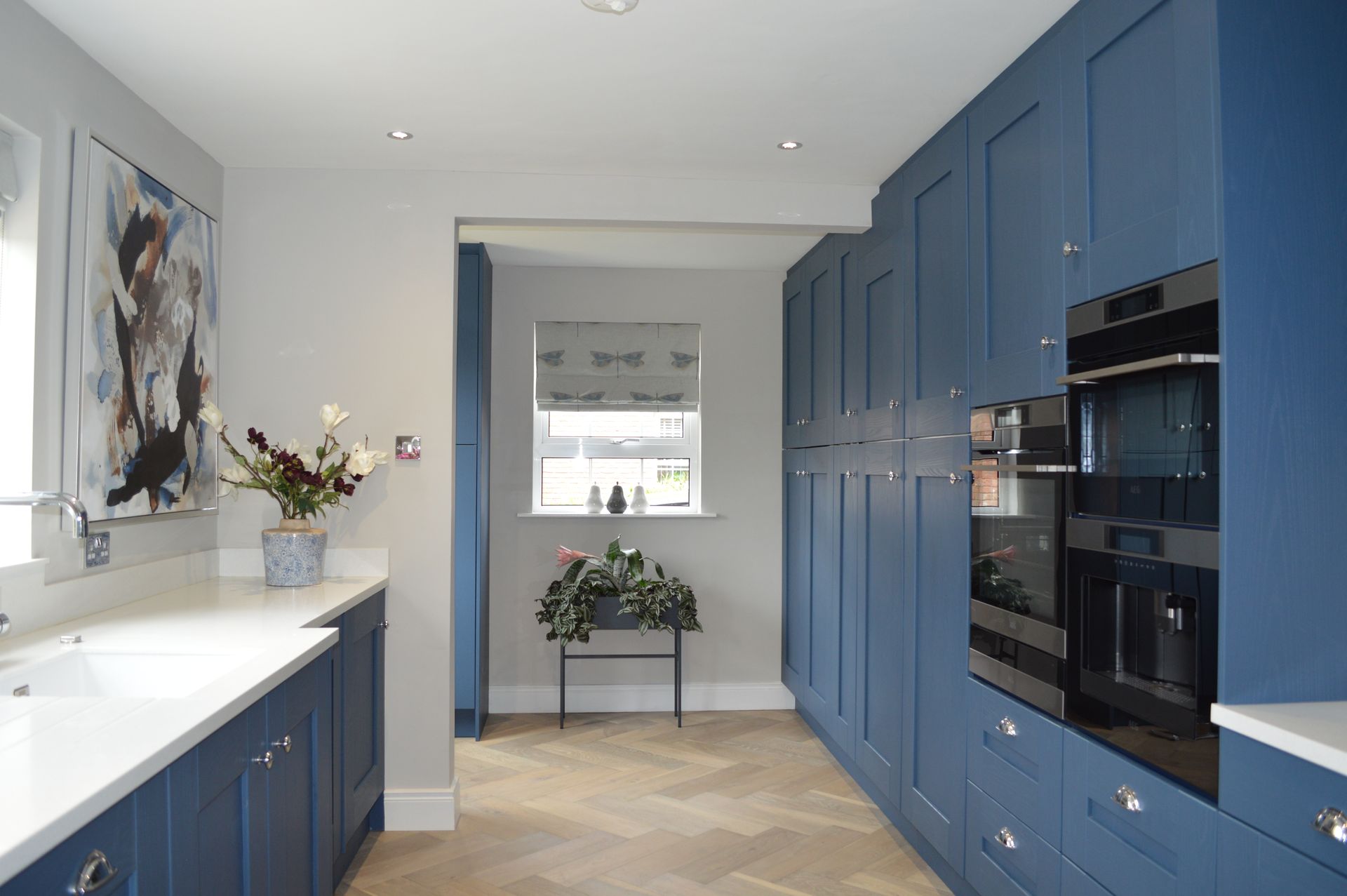 A kitchen with blue cabinets and a black oven.
