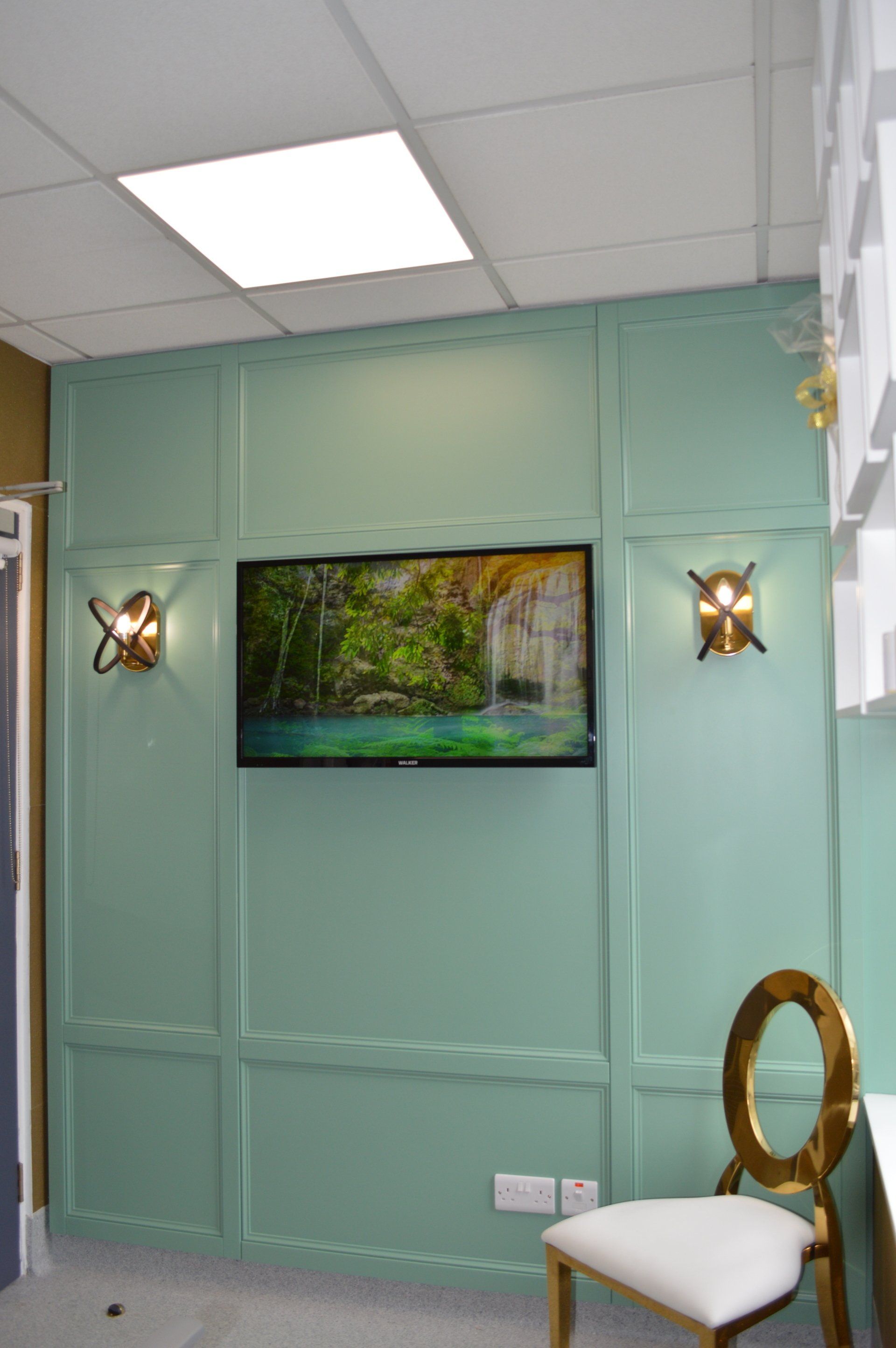 A room with a chair and a painting on the wall.