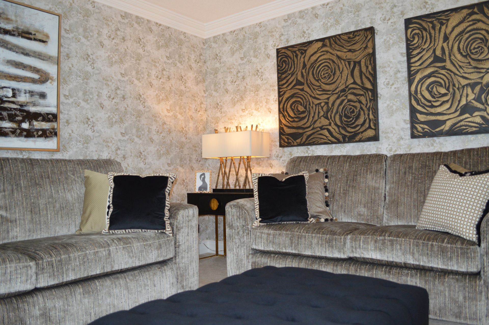 A living room with two couches and a black ottoman