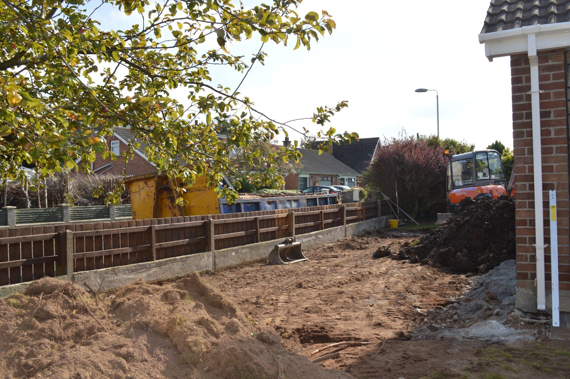 A large pile of dirt is in front of a brick building
