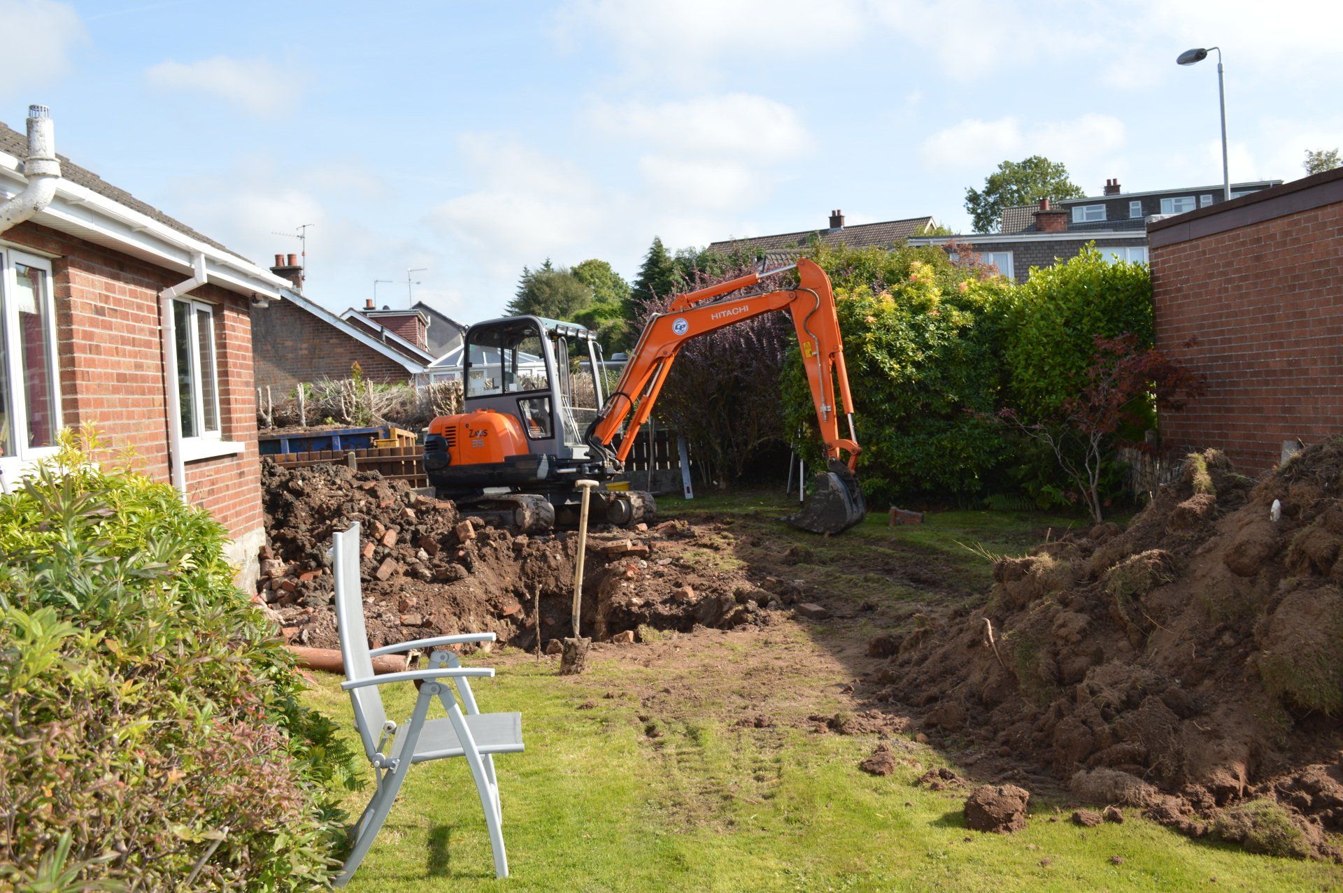 A large pile of dirt is being excavated in a backyard.